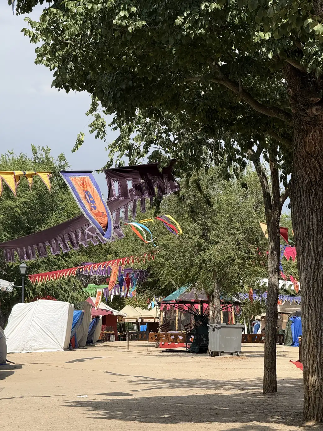Estandartes y carpas blancas entre los árboles del Mercado Medieval de Toledo. Foto propia La Maleta Inquieta, septiembre 2026.