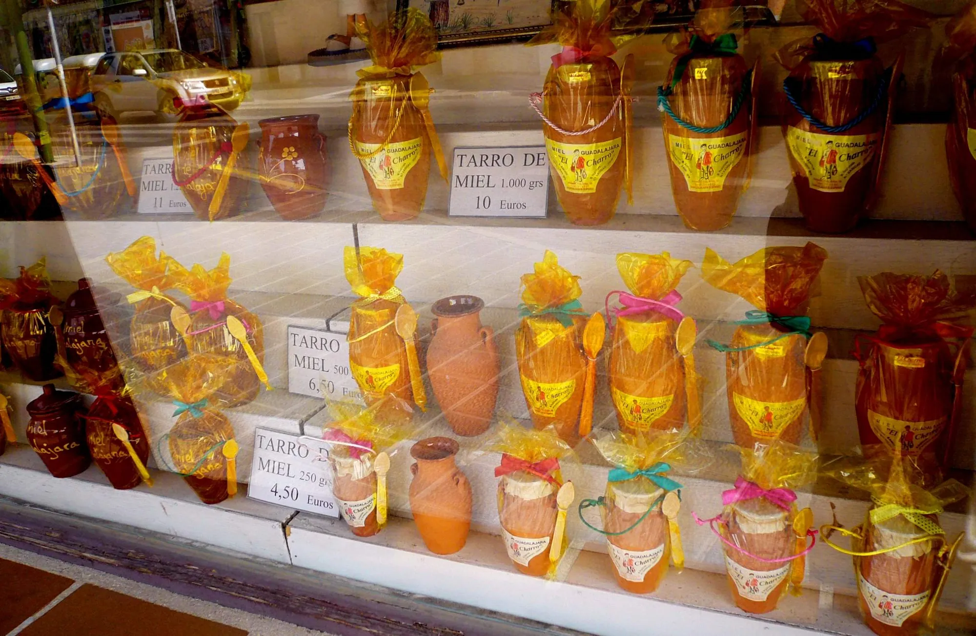 Tarros de miel de la Alcarria con sus precios en el escaparate de una tienda de Guadalajara