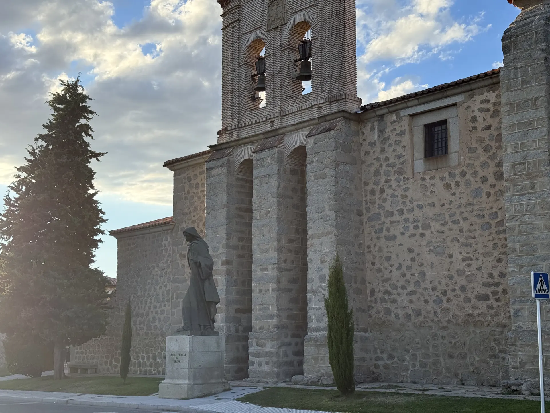 Estatua de Santa Teresa peregrina ante la espadaña de ladrillo de la Encarnación de Ávila al atardecer. Foto propia La Maleta Inquieta, septiembre 2026.