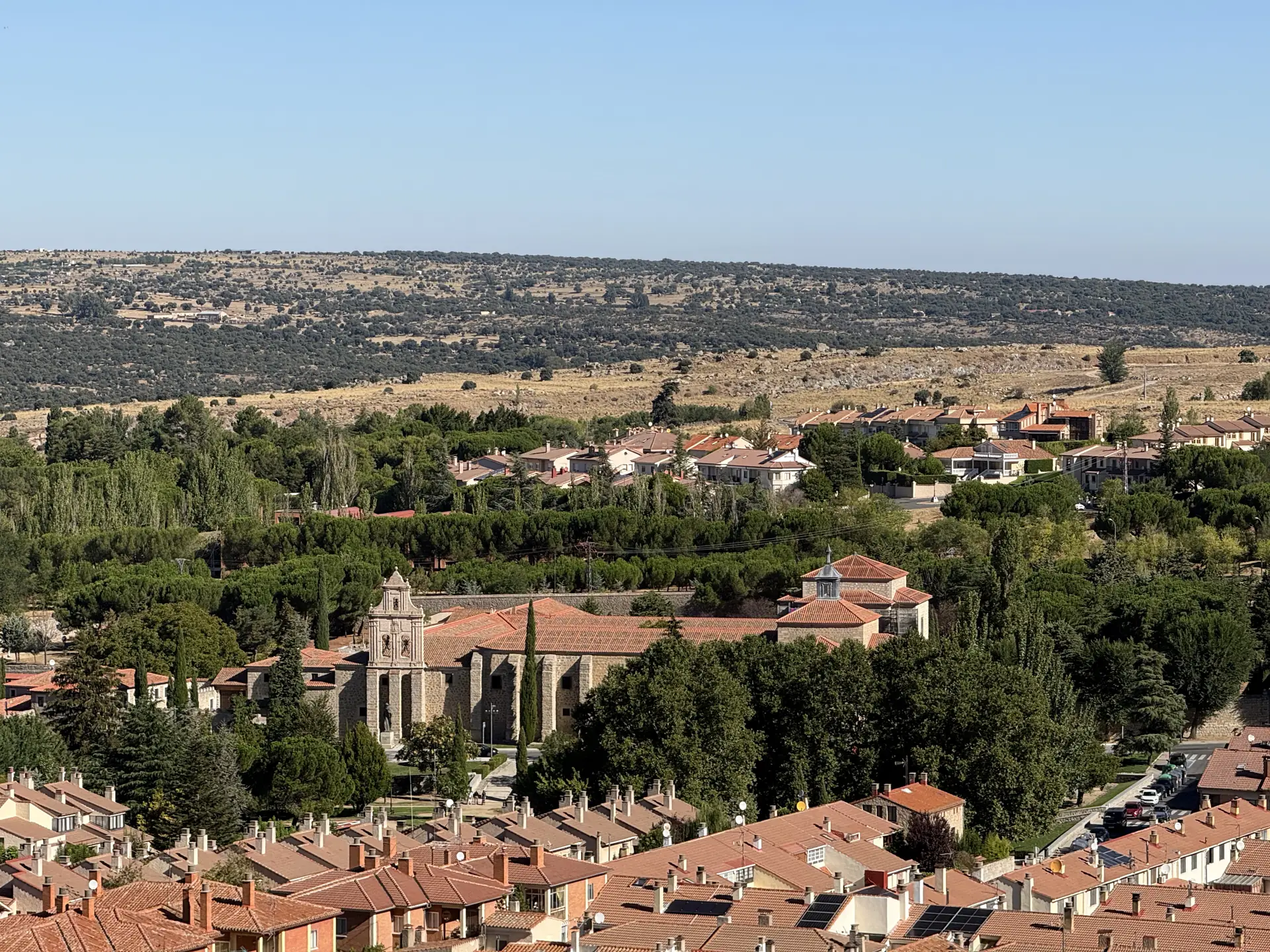 Monasterio de la Encarnación de Ávila entre pinos y cipreses, visto desde el adarve norte con la dehesa al fondo. Foto propia La Maleta Inquieta, septiembre 2026.