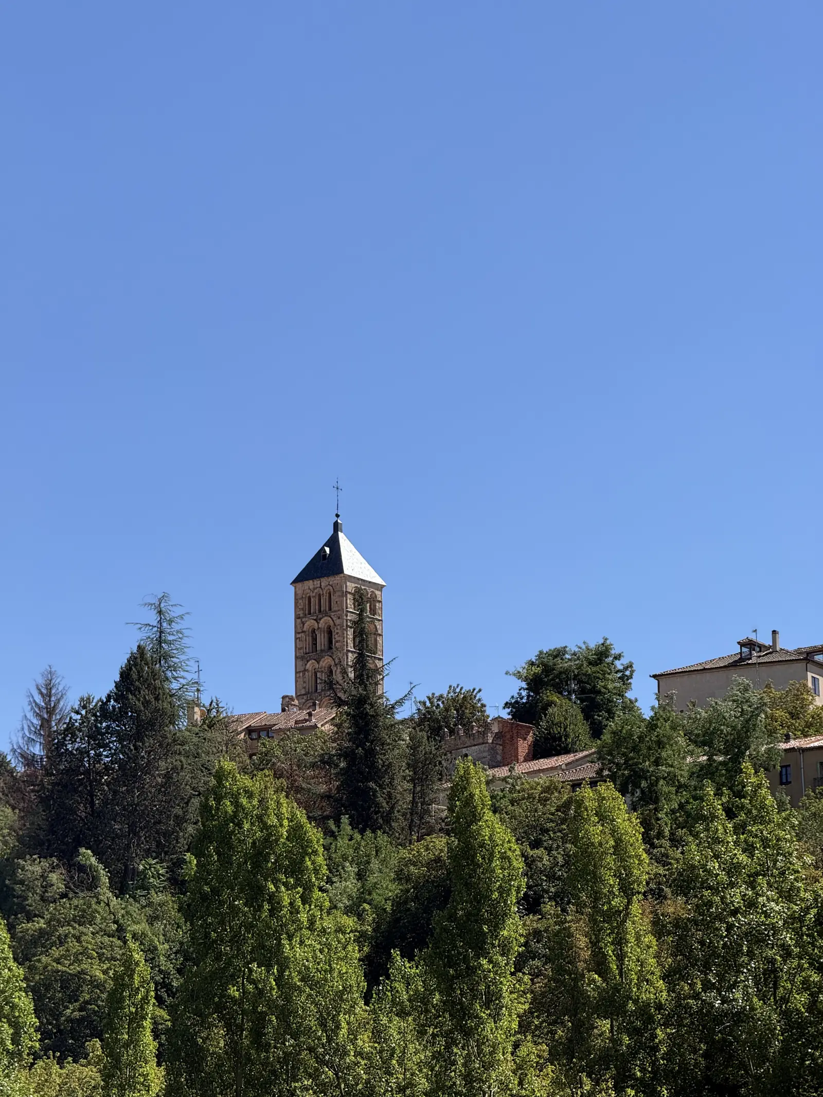 Torre del Monasterio del Parral de Segovia asomando entre las copas de los árboles del valle. Foto propia La Maleta Inquieta, septiembre 2026.