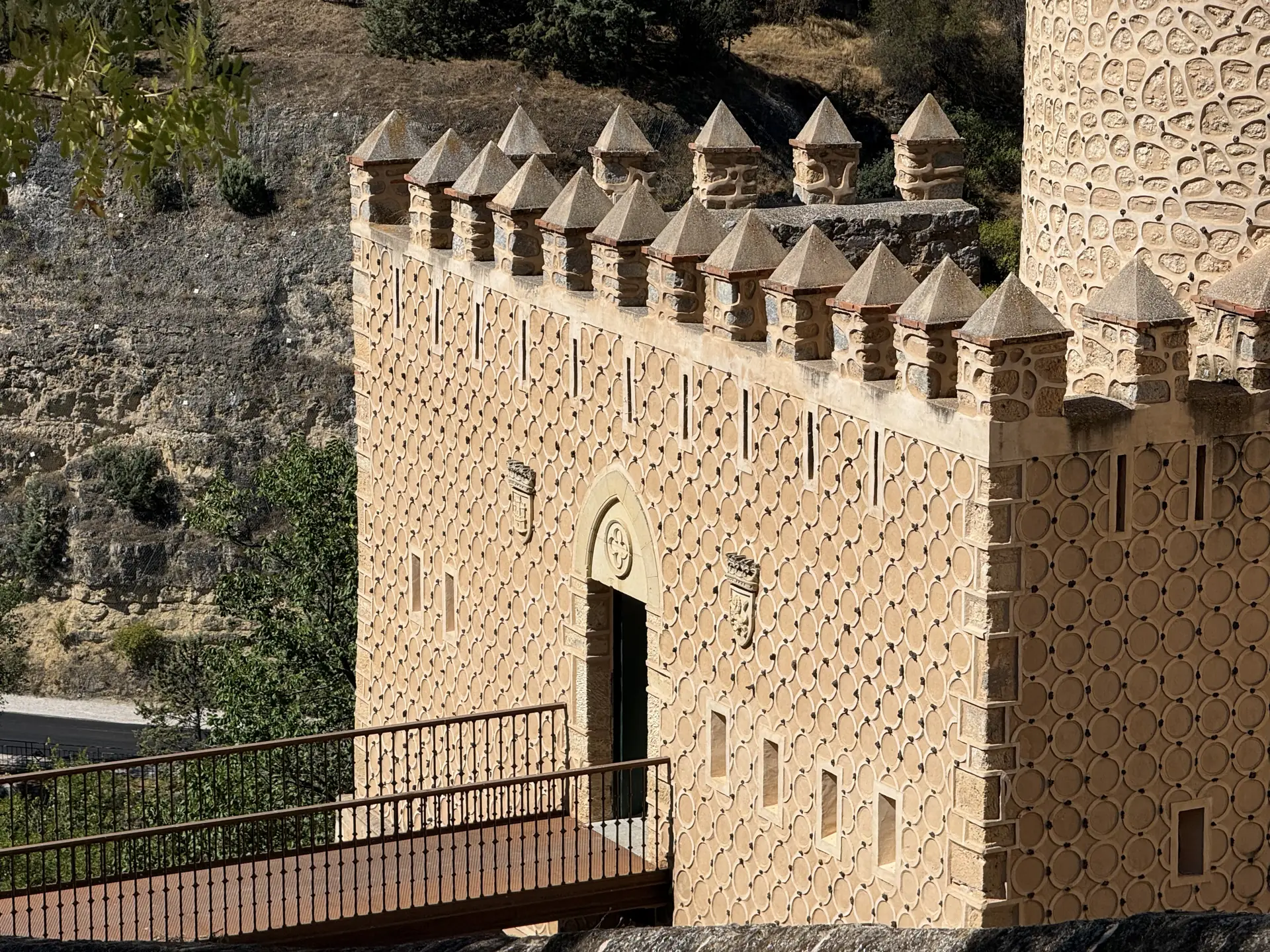 Muralla defensiva del Alcázar de Segovia con almenas piramidales y esgrafiado de círculos en la fachada. Foto propia La Maleta Inquieta, septiembre 2026.
