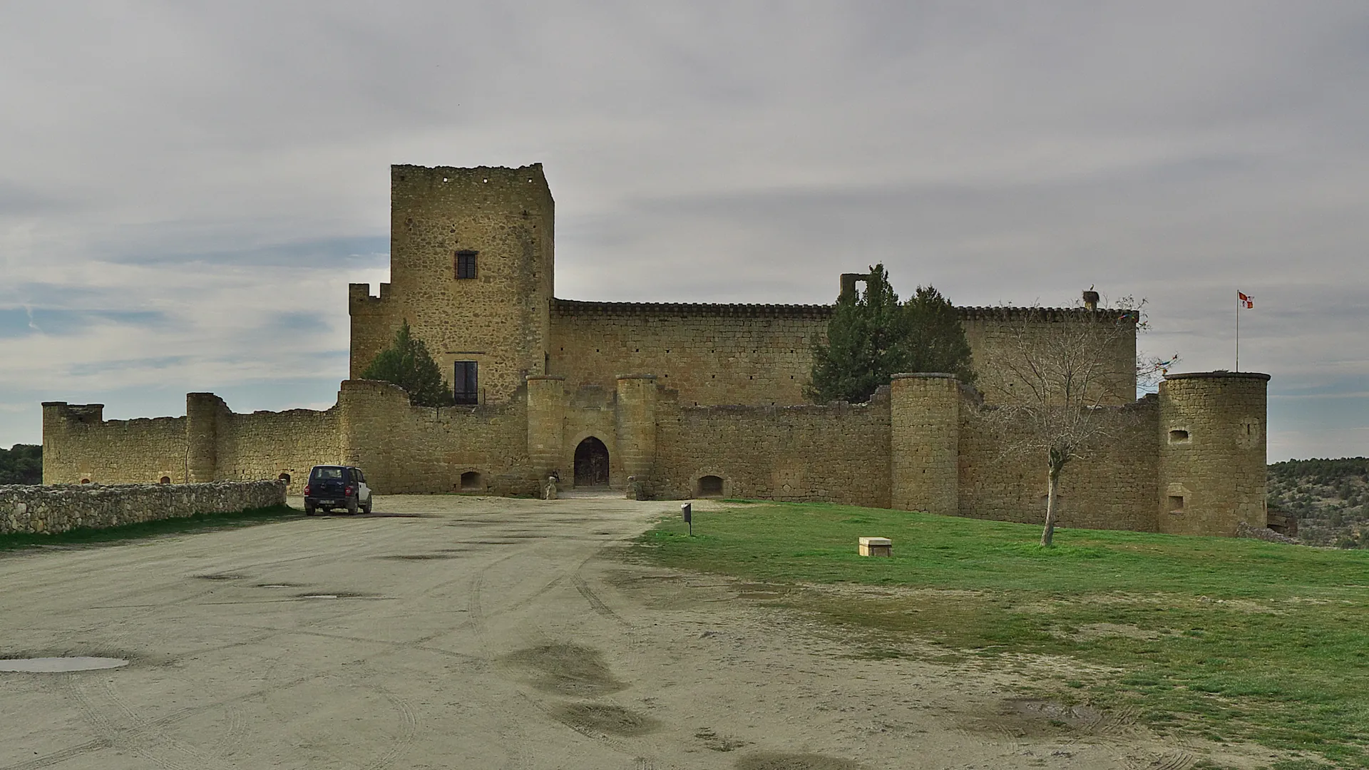 Castillo de Pedraza sobre la pradera, con el caserio amurallado del pueblo, en la provincia de Segovia.