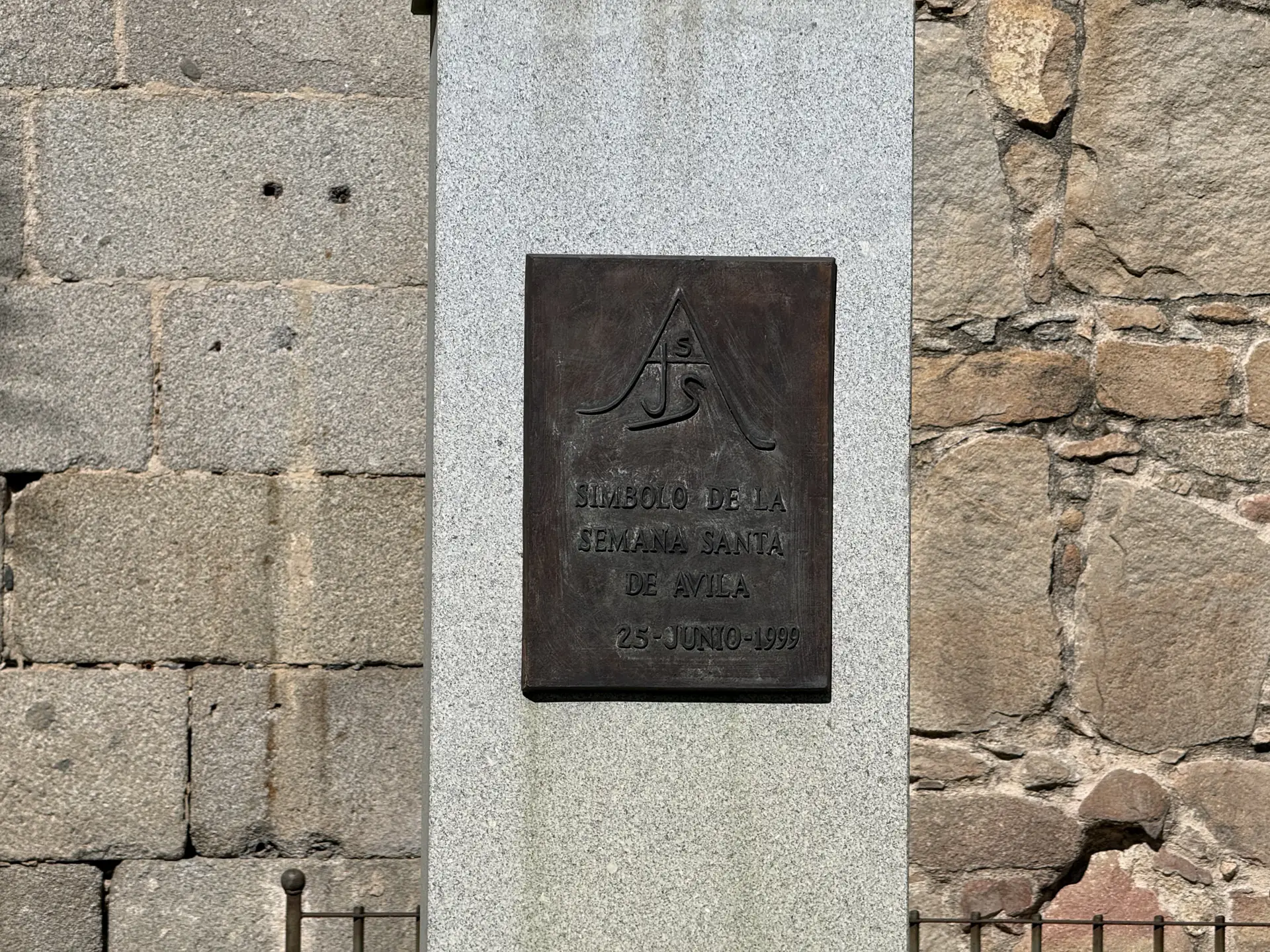 Placa de bronce del Símbolo de la Semana Santa de Ávila con anagrama y la fecha 25 de junio de 1999. Foto propia La Maleta Inquieta, septiembre 2026.