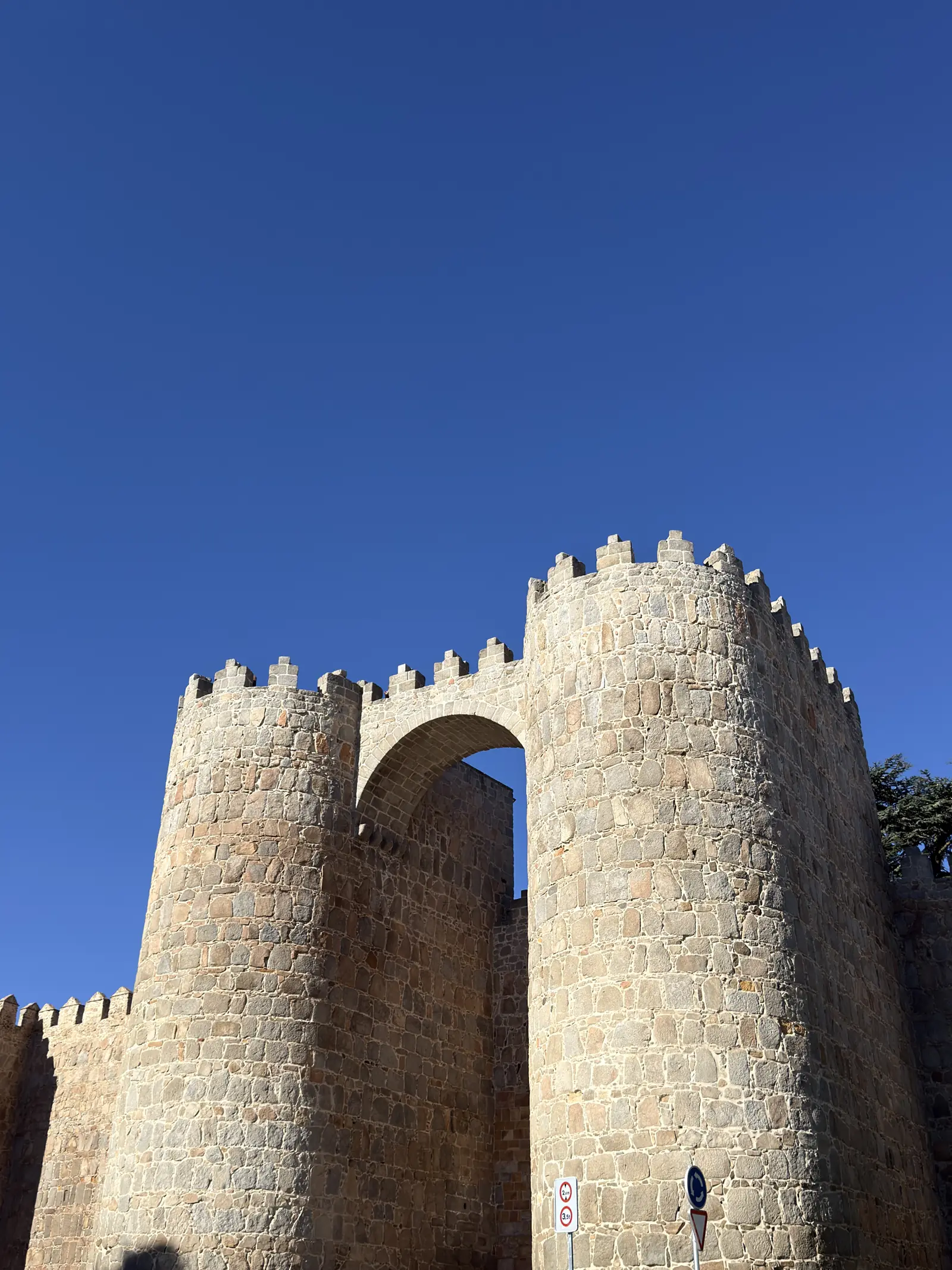 Puerta de San Vicente de la muralla de Ávila, con dos cubos almenados unidos por un arco sobre el cielo azul. Foto propia La Maleta Inquieta, septiembre 2026