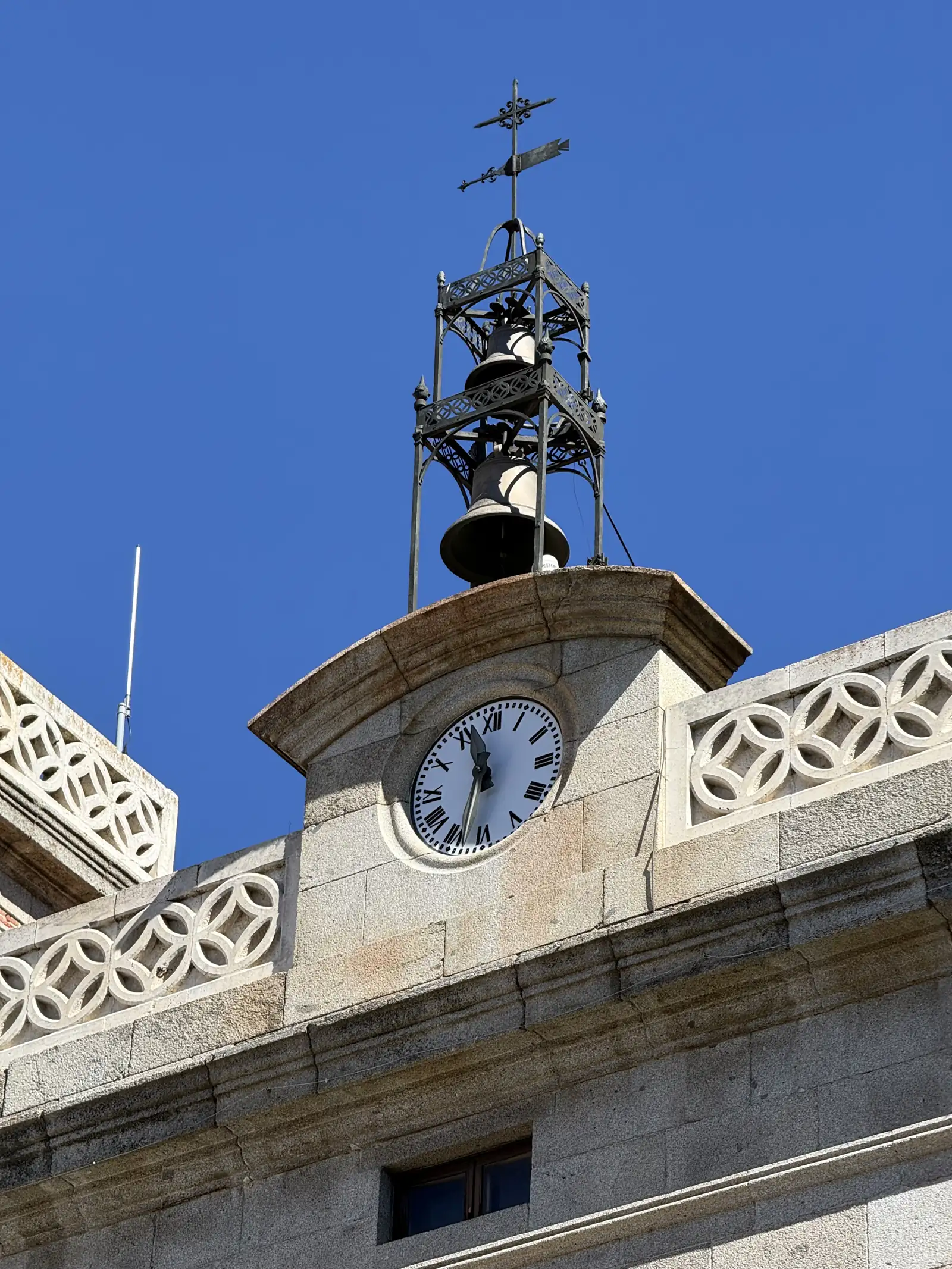 Reloj y templete de forja con dos campanas y veleta en el remate de la fachada del Ayuntamiento de Ávila. Foto propia La Maleta Inquieta, septiembre 2026.
