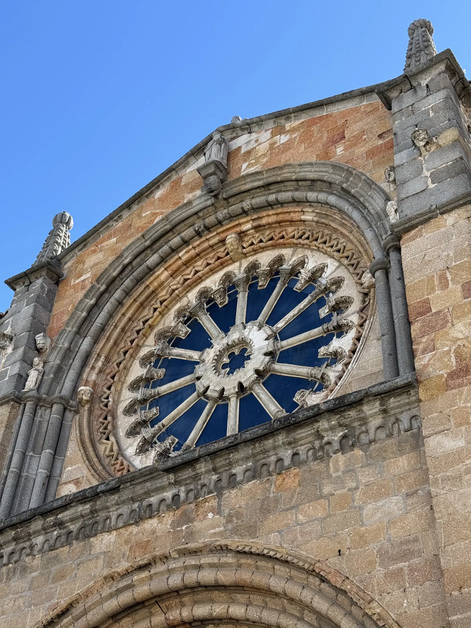 Rosetón de columnillas radiales de la iglesia de San Pedro de Ávila visto desde abajo, con su piñón de piedra. Foto propia La Maleta Inquieta, septiembre 2026.