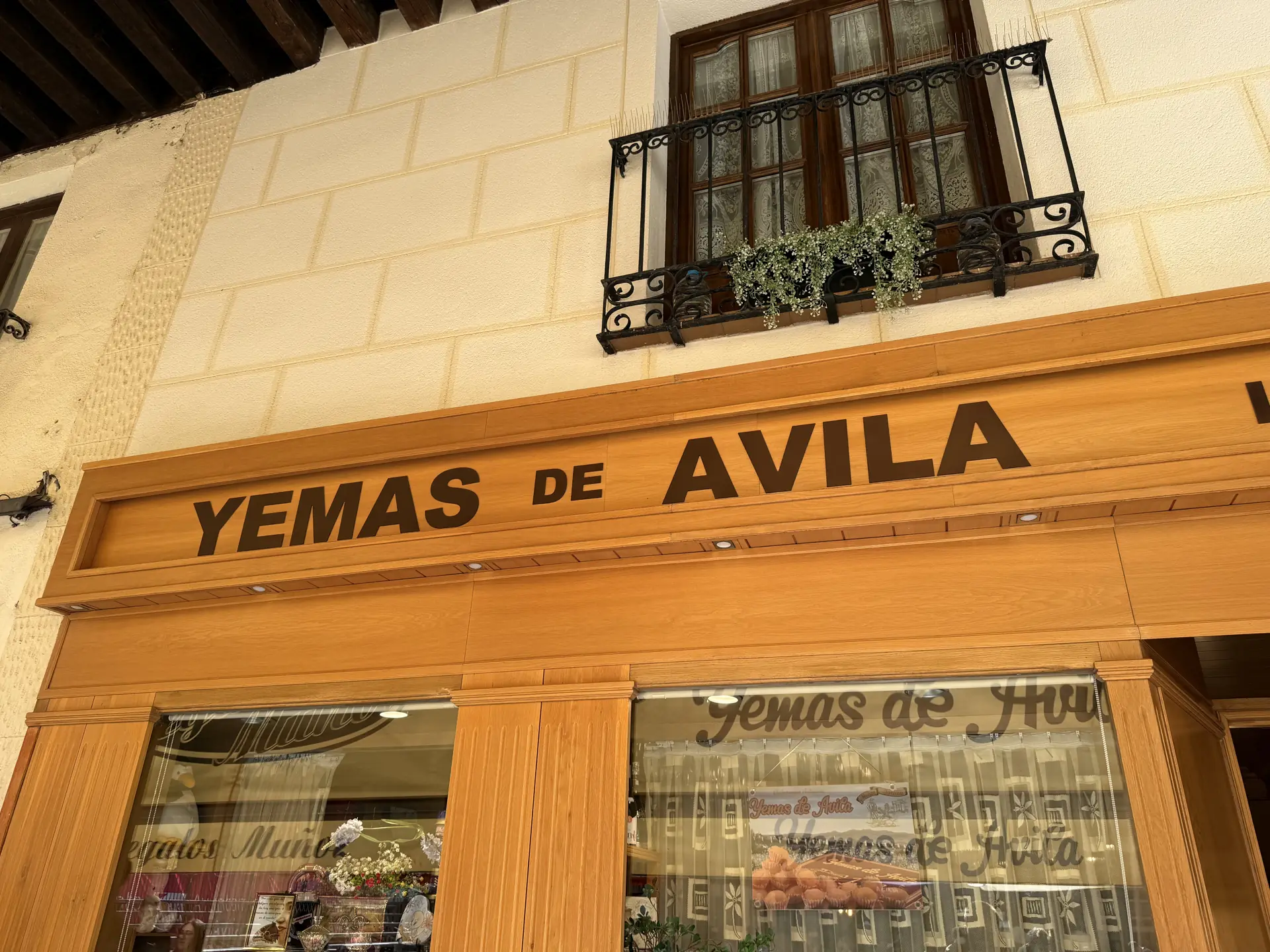 Rótulo de madera Yemas de Ávila sobre el escaparate de una pastelería en los soportales del Mercado Chico. Foto propia La Maleta Inquieta, septiembre 2026