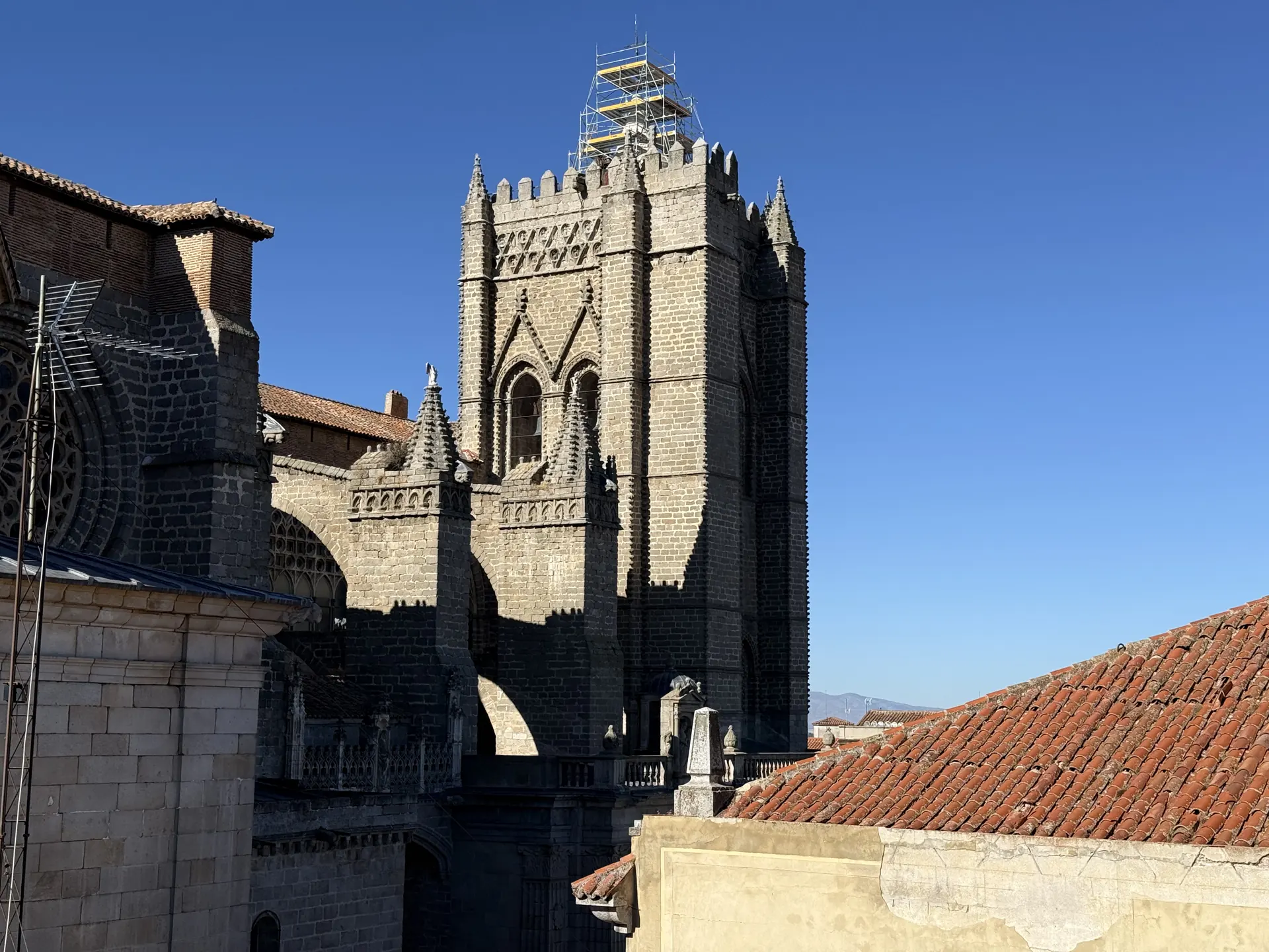 Torre de granito de la catedral de Ávila con andamio en el remate y pináculos góticos, vista desde el adarve. Foto propia La Maleta Inquieta, septiembre 2026.