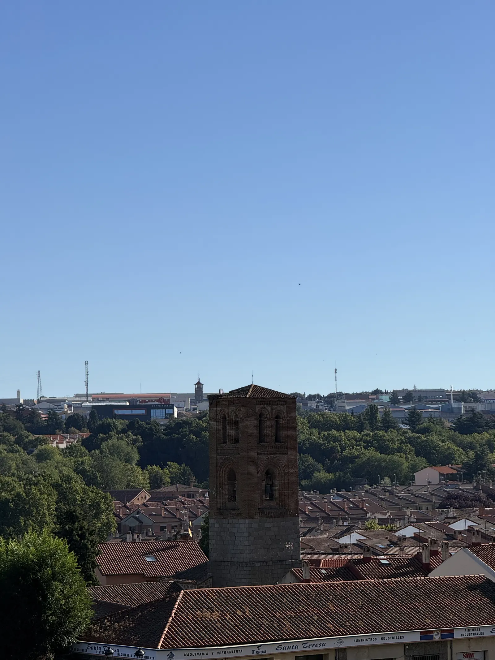 Torre mudéjar de ladrillo sobre base de granito de la iglesia de San Martín, entre los tejados del norte de Ávila. Foto propia La Maleta Inquieta, septiembre 2026.