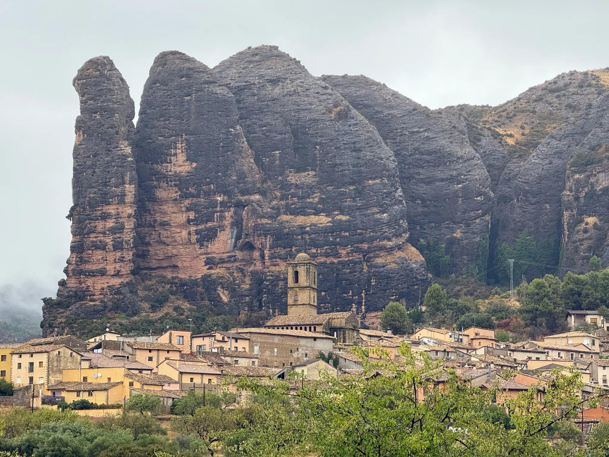 Vista del pueblo de Agüero con su iglesia y las formaciones rocosas de conglomerado al fondo. Foto propia La Maleta Inquieta, octubre 2026
