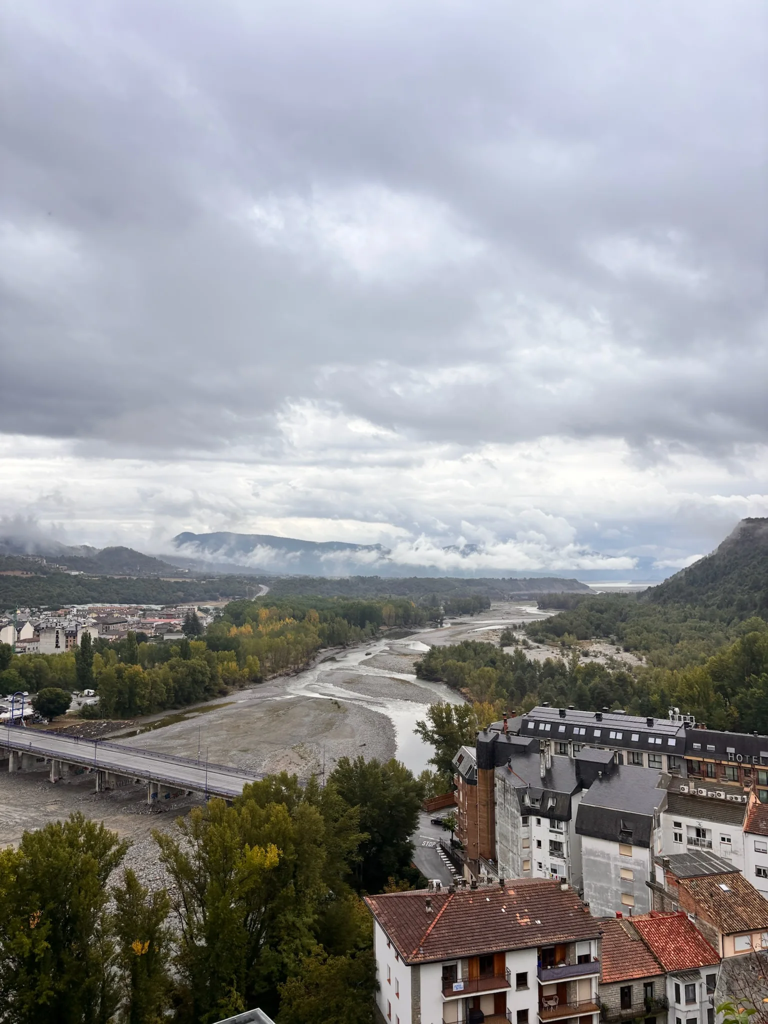 Confluencia de los ríos Cinca y Ara desde Aínsa, con el pueblo nuevo y montañas cubiertas de nubes. Foto propia La Maleta Inquieta, octubre 2026