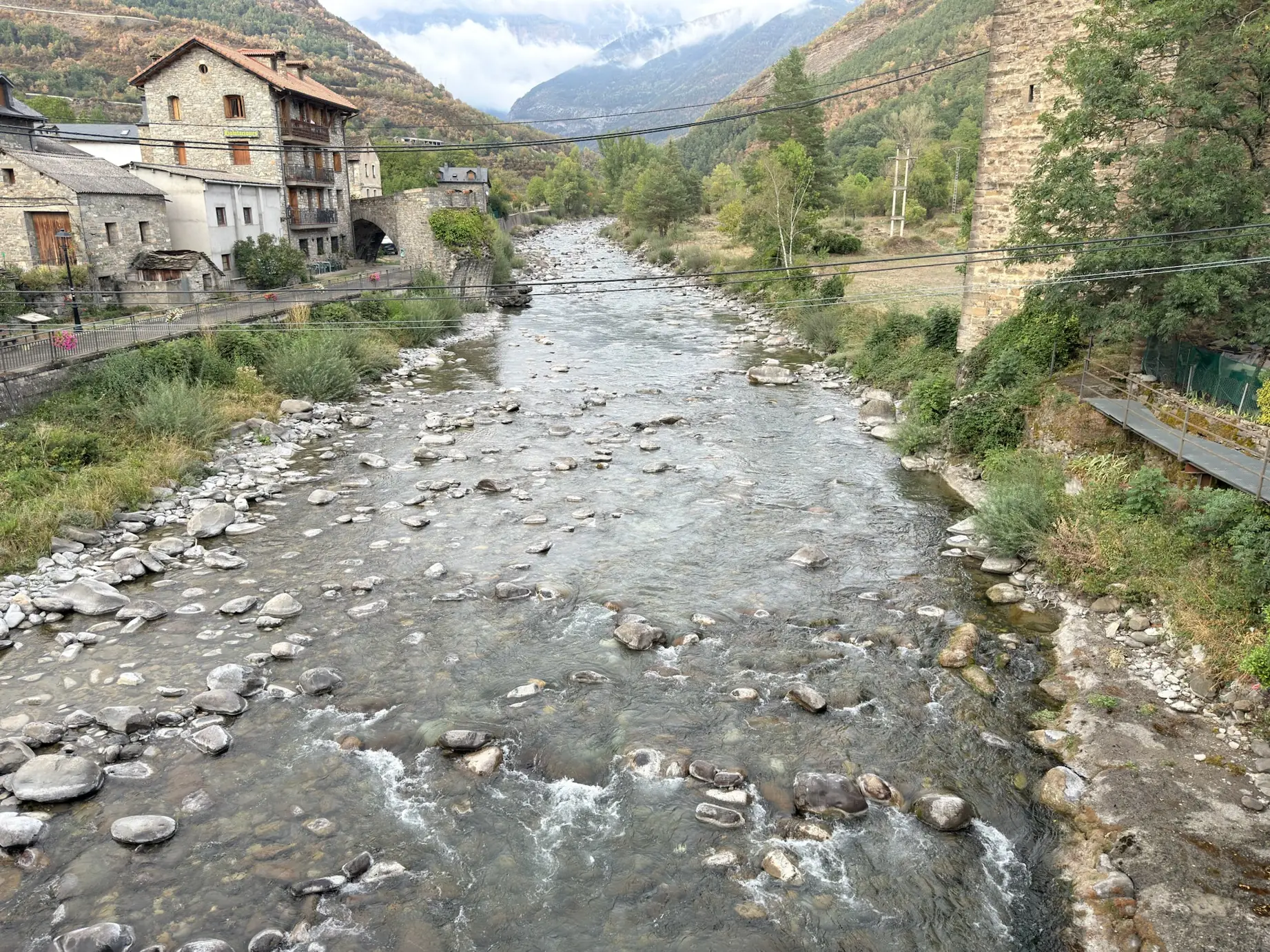 Río Ara con casas de piedra tradicionales a ambos lados y montañas pirenaicas en Broto. Foto propia La Maleta Inquieta, octubre 2026