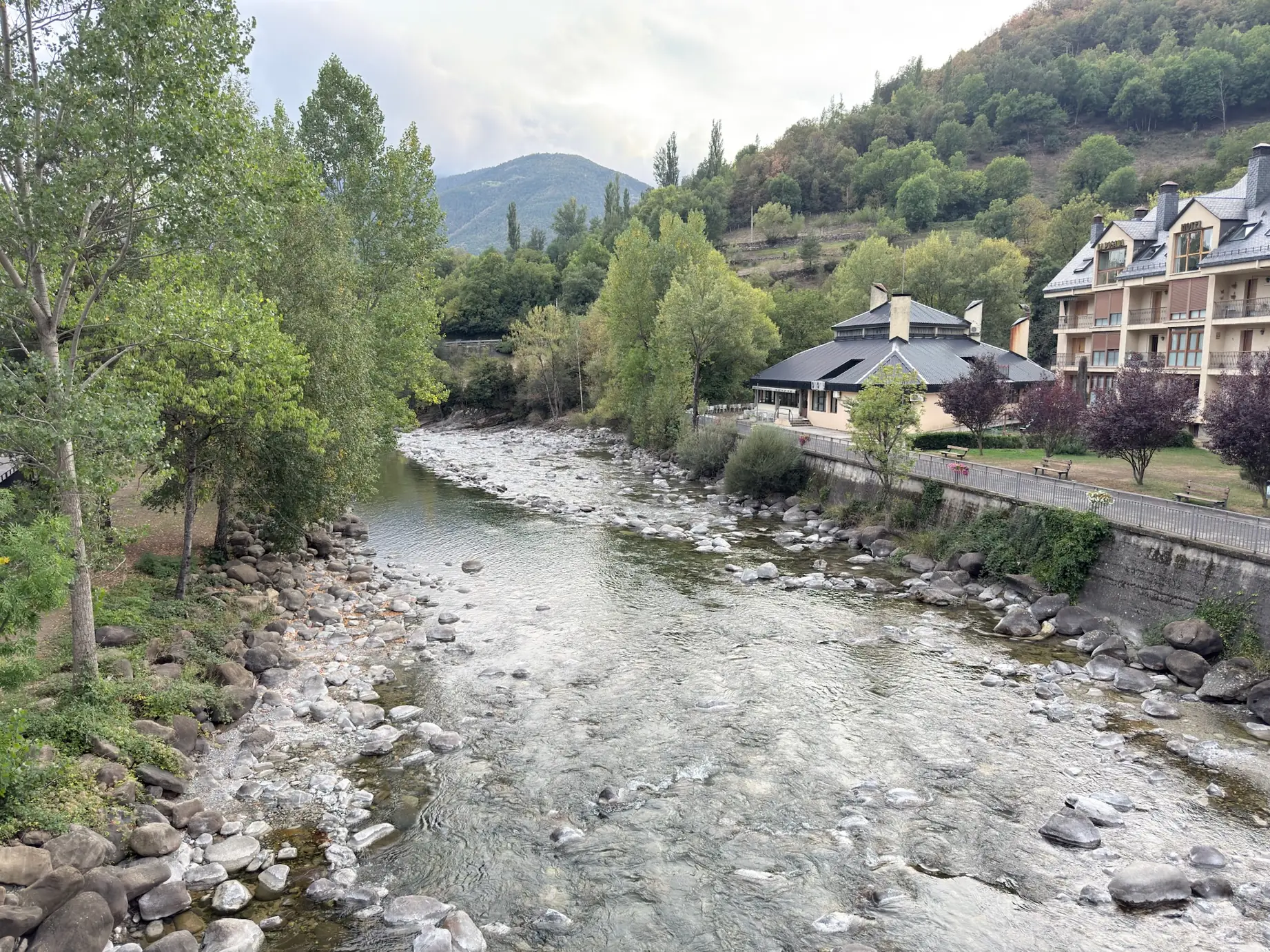 Río Ara con lecho rocoso y agua clara atravesando Broto con edificios a ambos lados y montañas al fondo. Foto propia La Maleta Inquieta, octubre 2026