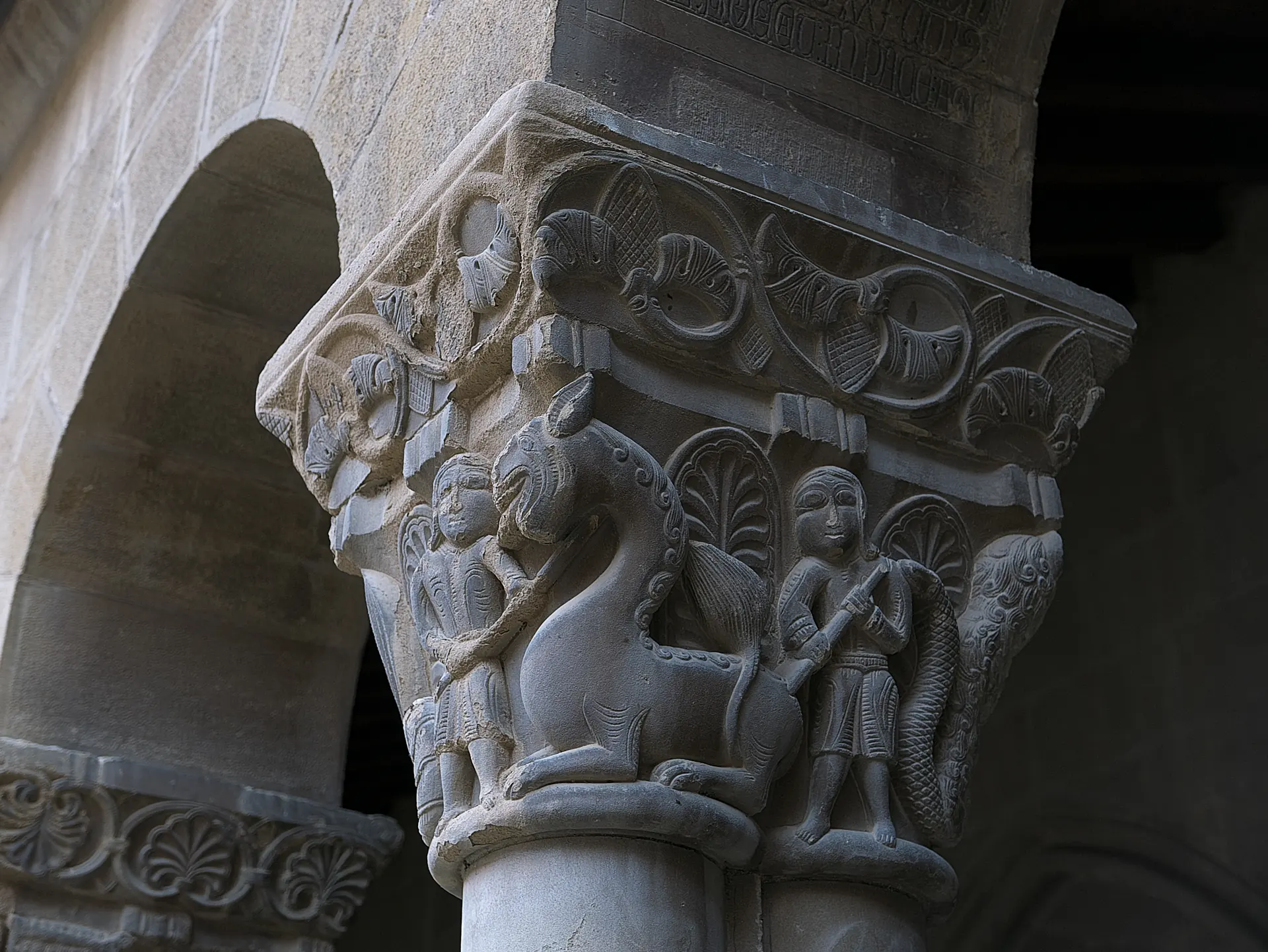 Capitel historiado del claustro de San Pedro el Viejo en Huesca, con dos figuras, un animal fantástico y una serpiente
