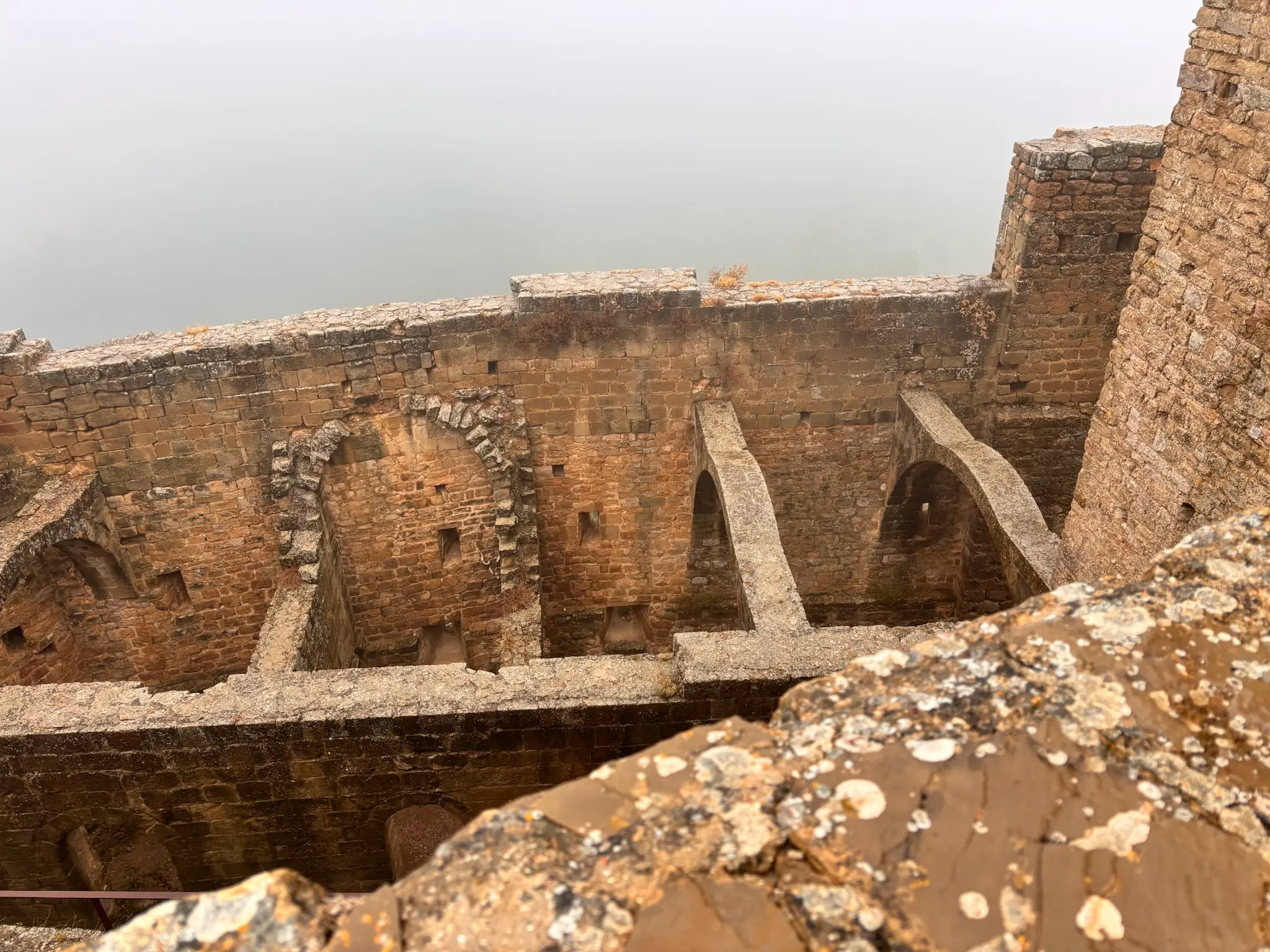Vista desde arriba de las estancias interiores del castillo de Loarre con arcos de piedra y muros medievales. Foto propia La Maleta Inquieta, octubre 2026