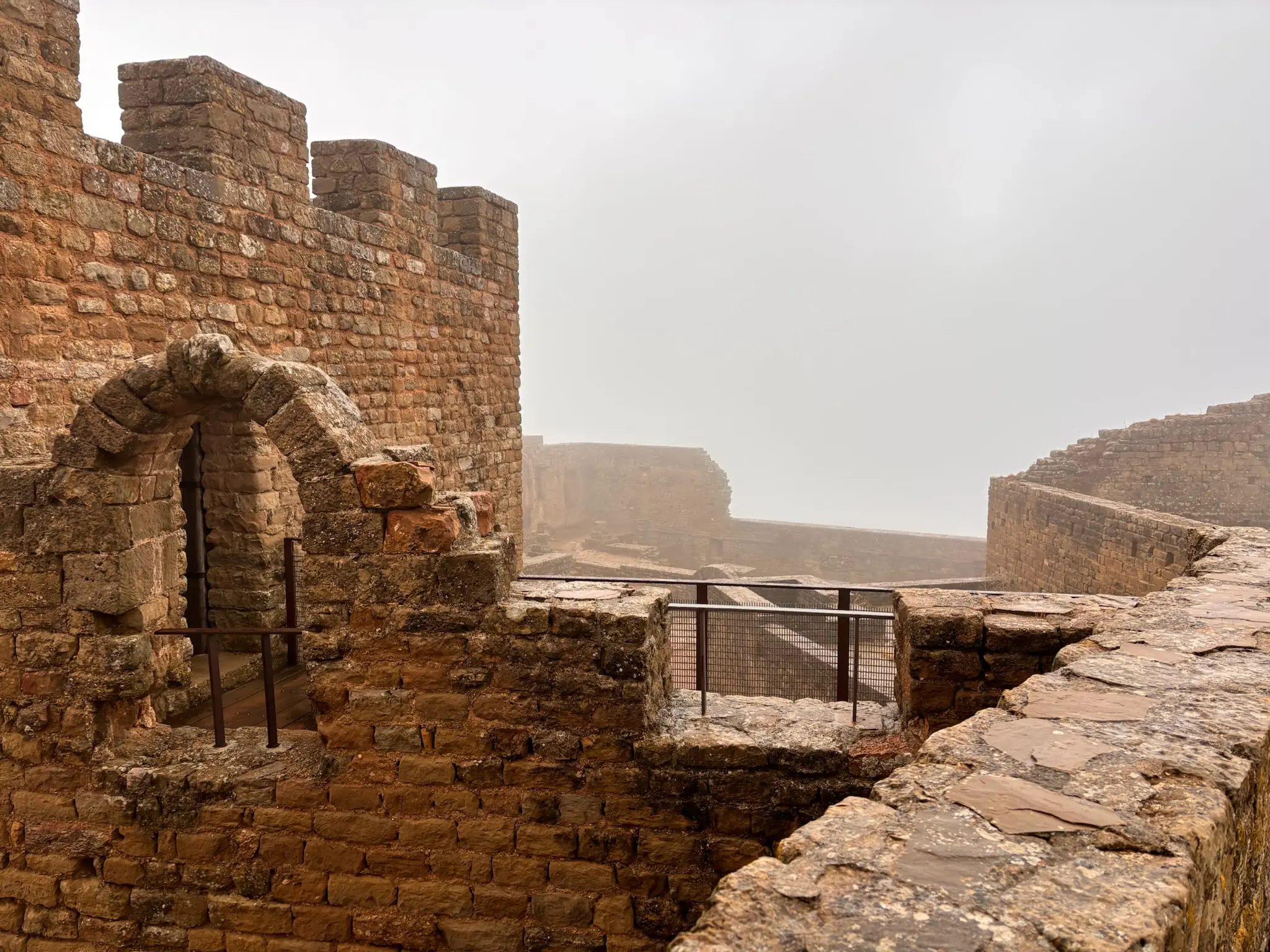 Murallas almenadas del castillo de Loarre envueltas en niebla con vistas desde el adarve. Foto propia La Maleta Inquieta, octubre 2026
