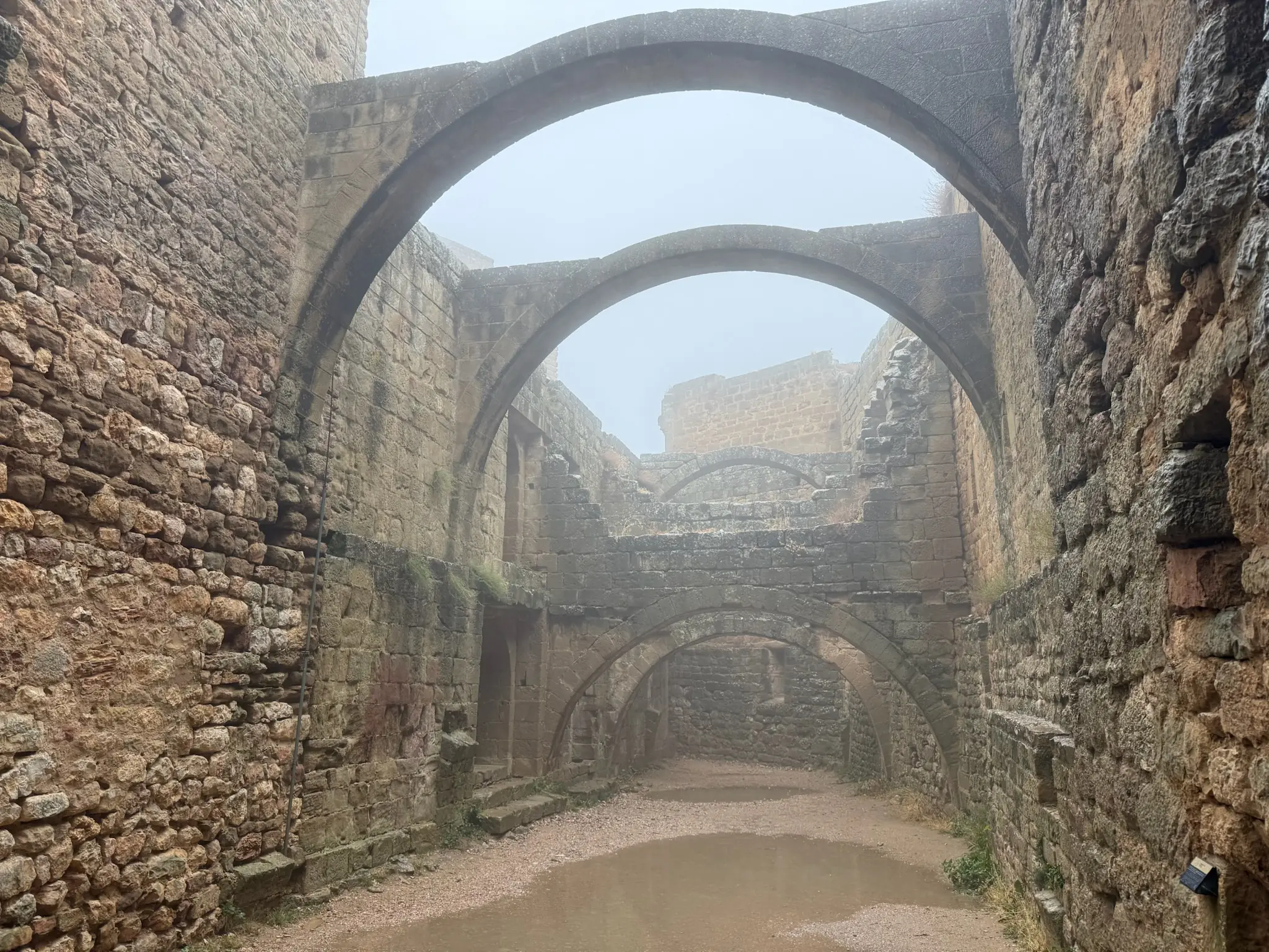 Pasillo con arcos sucesivos de piedra en perspectiva en el castillo de Loarre. Foto propia La Maleta Inquieta, octubre 2026