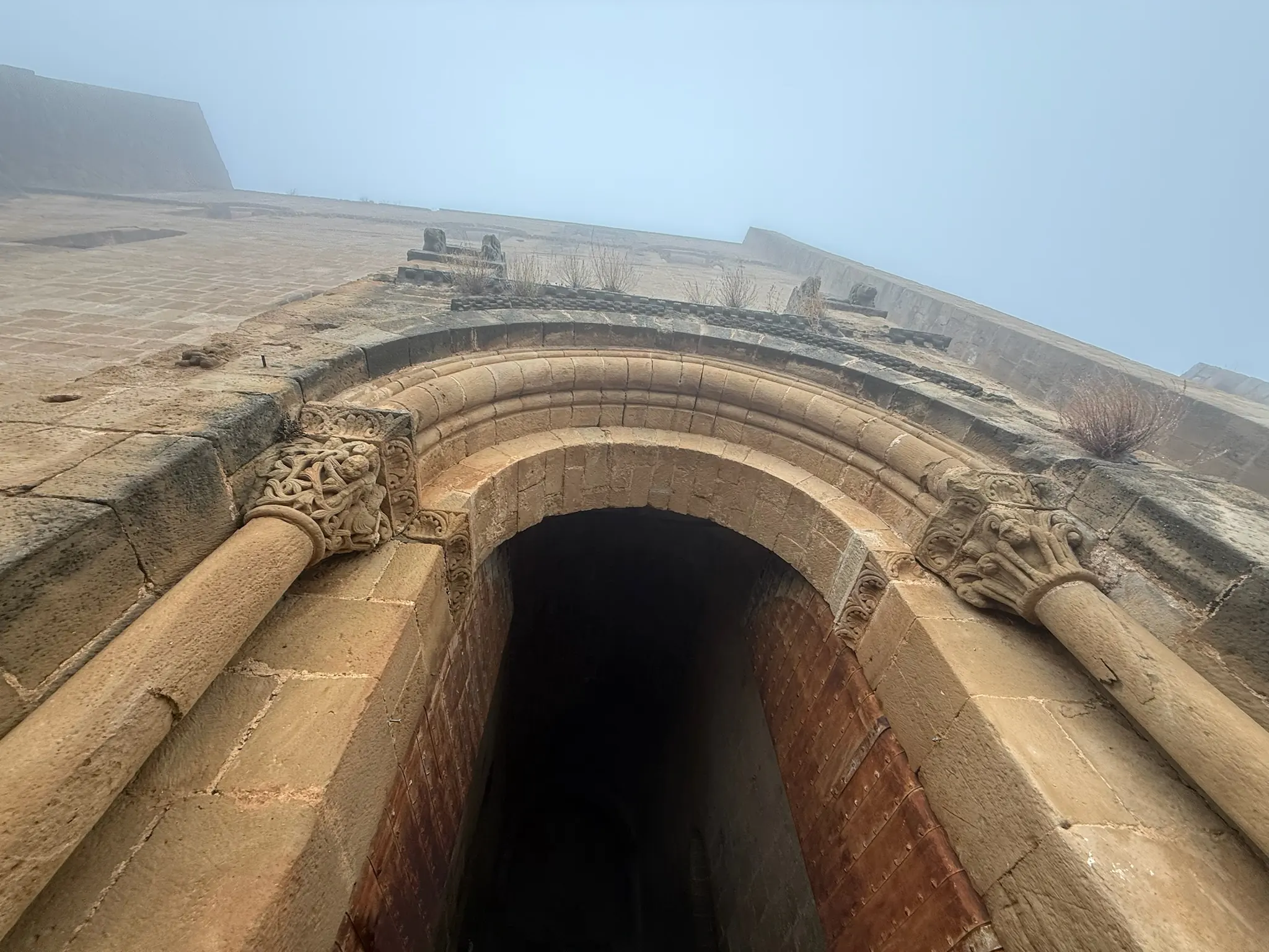 Portada románica del castillo de Loarre con arco decorado y capiteles tallados vista desde abajo. Foto propia La Maleta Inquieta, octubre 2026