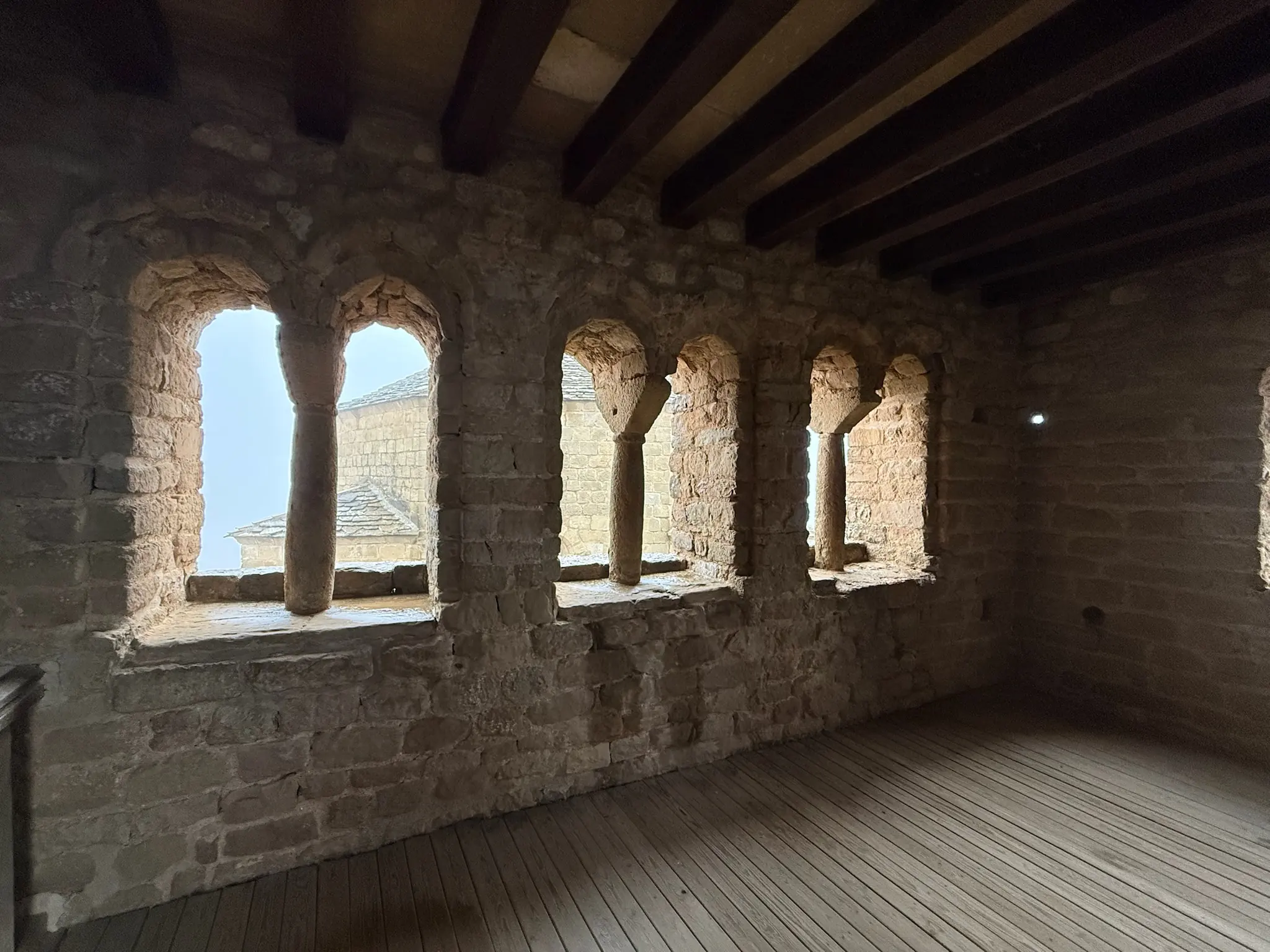 Sala interior del castillo de Loarre con ventanas geminadas con parteluces, techo y suelo de madera. Foto propia La Maleta Inquieta, octubre 2026