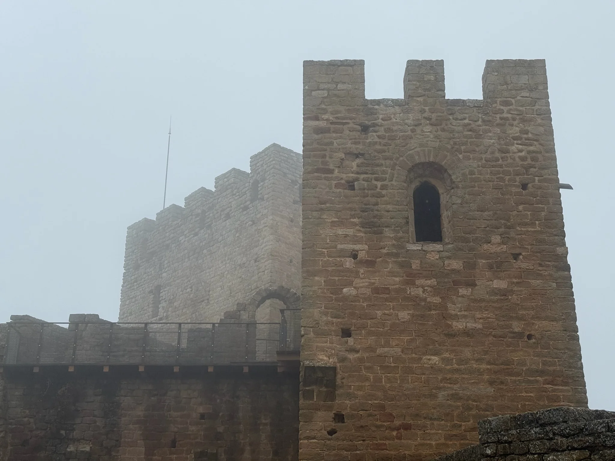 Torre del homenaje del castillo de Loarre con almenas y ventana saetera vista desde abajo. Foto propia La Maleta Inquieta, octubre 2026