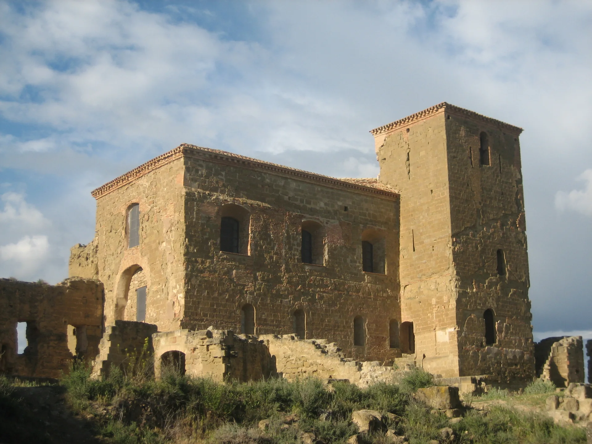 Iglesia de la abadía y torre del castillo de Montearagón vistas desde dentro del recinto, entre muros de sillar caídos