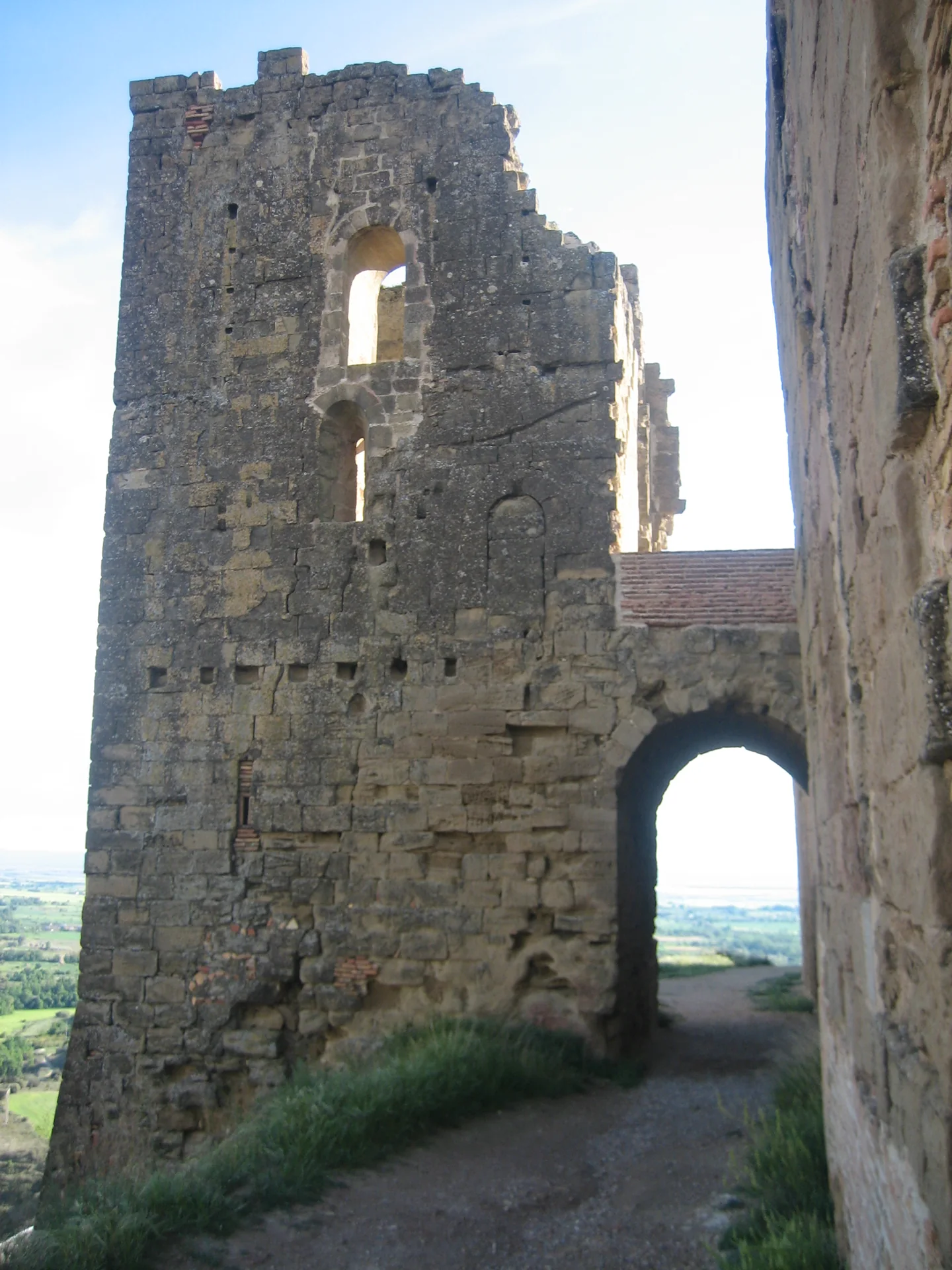 Torre de sillar del castillo de Montearagón junto al arco de paso del recinto, con la Hoya de Huesca al fondo