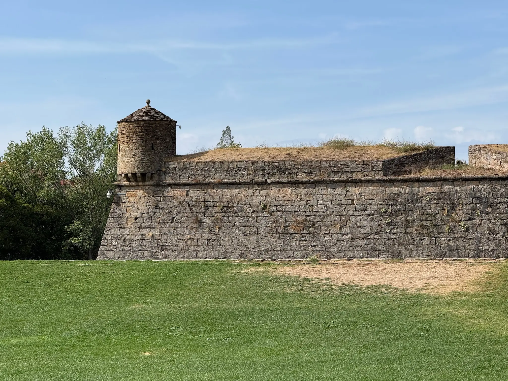Muralla de la Ciudadela de Jaca con torre cilíndrica de piedra, baluartes y césped exterior. Foto propia La Maleta Inquieta, octubre 2026