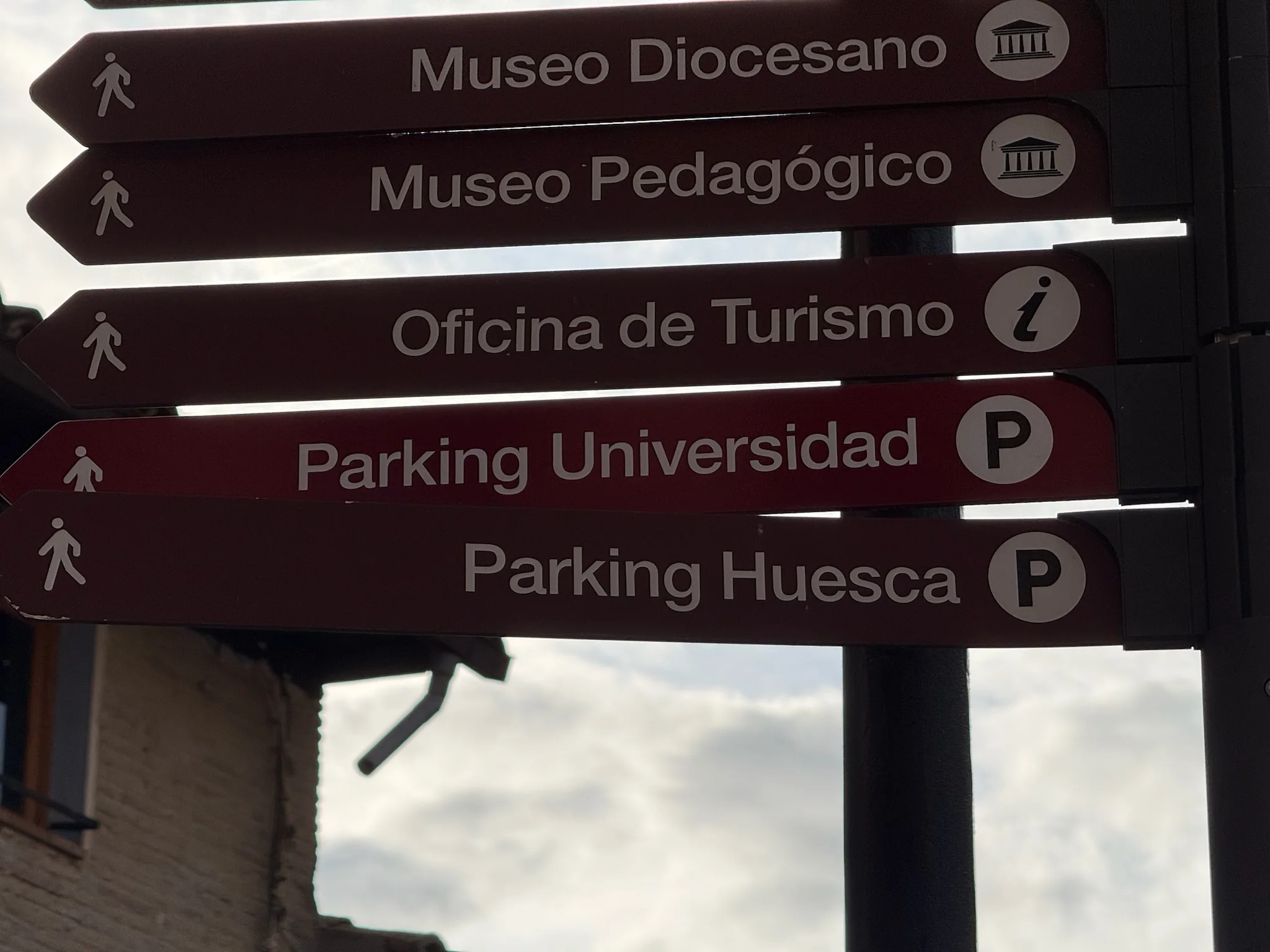 Detalle de poste con indicaciones a Museo Diocesano, Museo Pedagógico, Oficina de Turismo y parkings en Huesca. Foto propia La Maleta Inquieta, octubre 2026