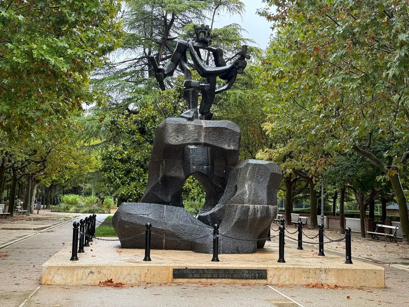 Monumento a los reyes de Aragón en el Parque Miguel Servet de Huesca, una figura coronada sobre bloques de piedra oscura entre árboles. Foto propia La Maleta Inquieta, octubre 2026