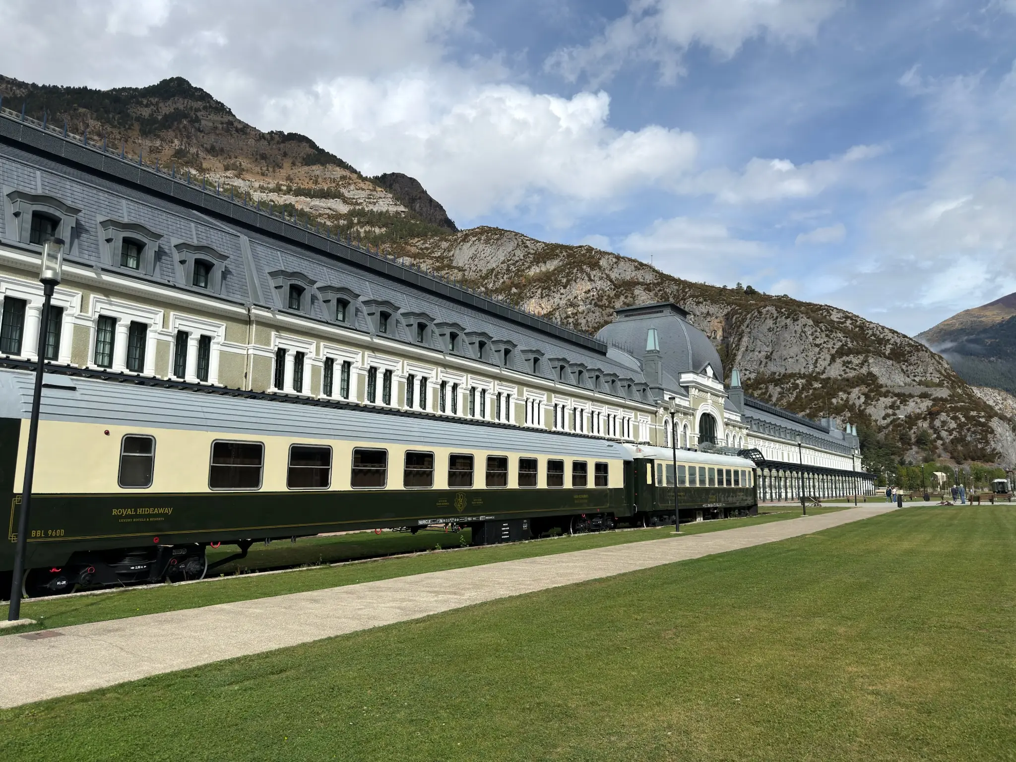 Vagón de tren Royal Hideaway frente a la Estación de Canfranc con las montañas del Pirineo al fondo. Foto propia La Maleta Inquieta, octubre 2026