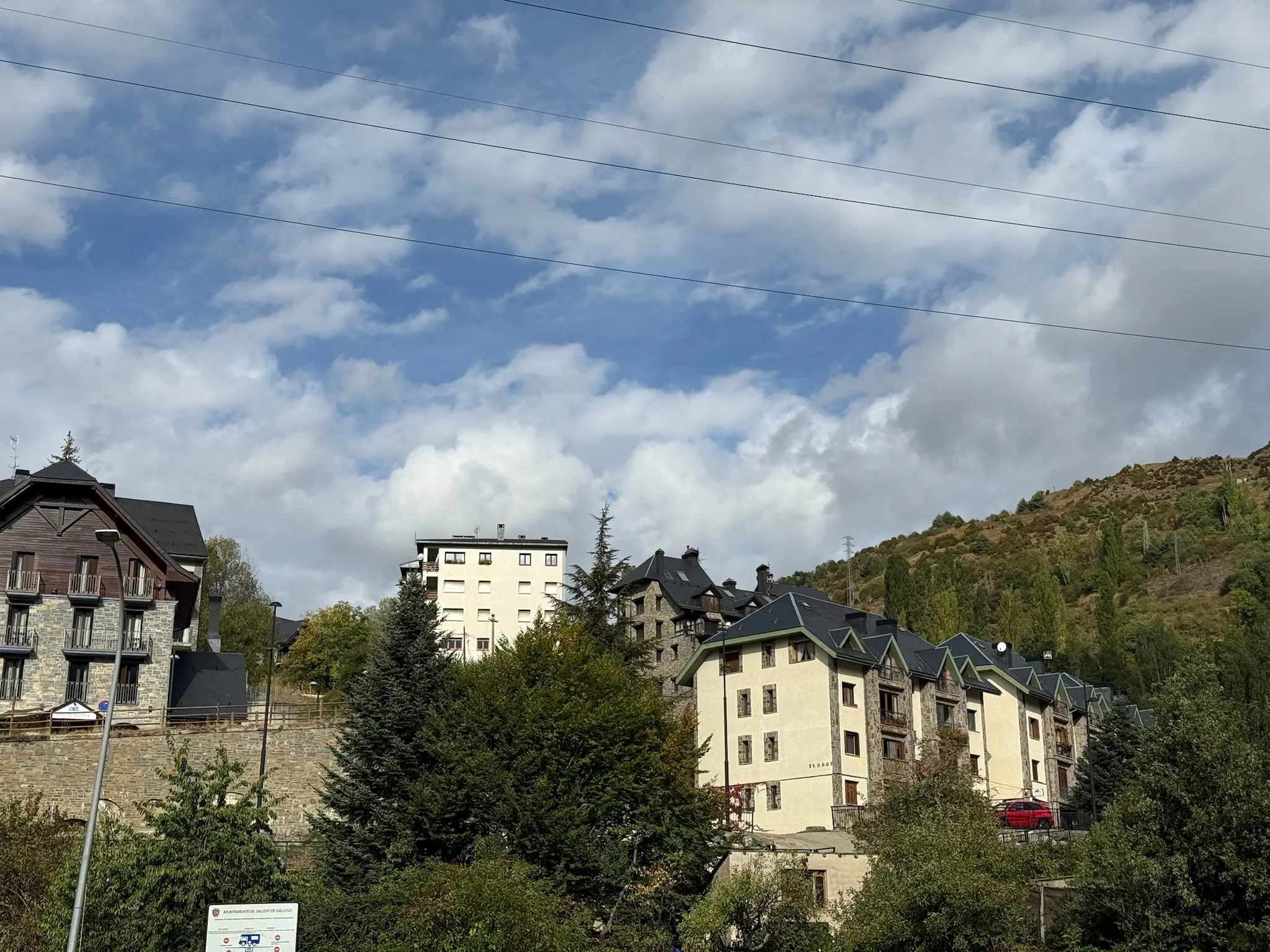 Edificios de apartamentos en Formigal con montañas del Valle de Tena al fondo bajo cielo nublado