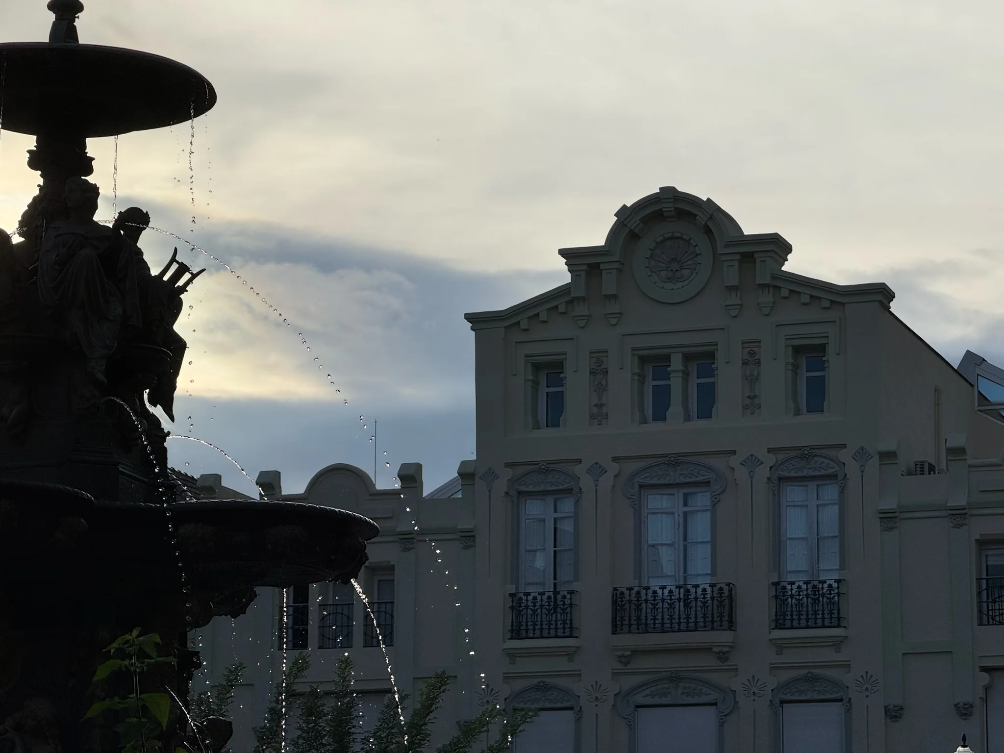 Silueta de fuente monumental con edificio señorial al fondo al atardecer en Huesca. Foto propia La Maleta Inquieta, octubre 2026