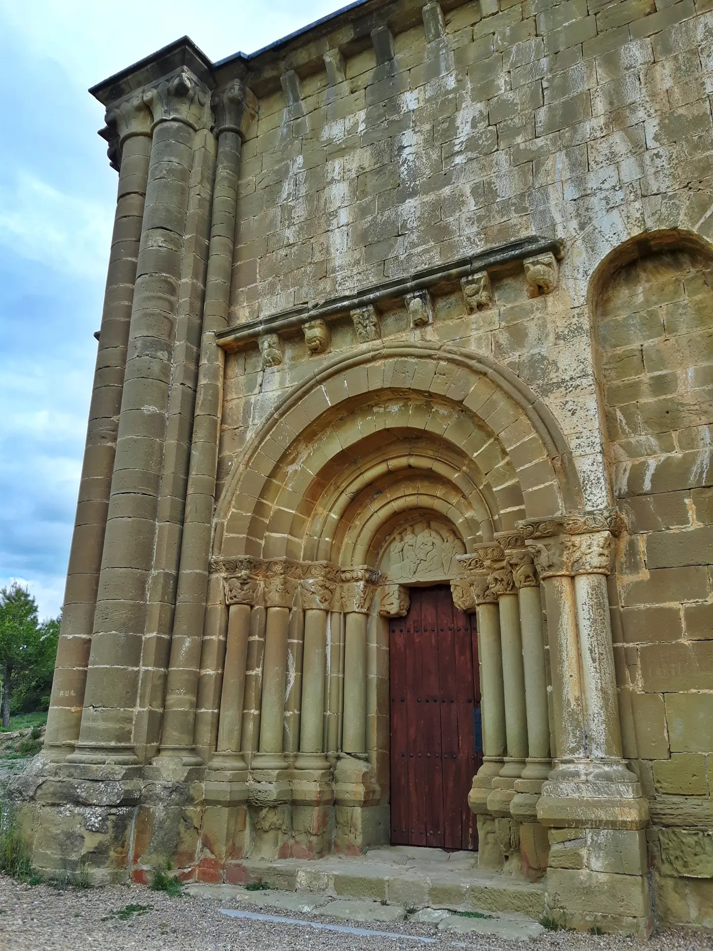 Portada románica de la iglesia de Santiago de Agüero, con arquivoltas y columnas de piedra arenisca dorada
