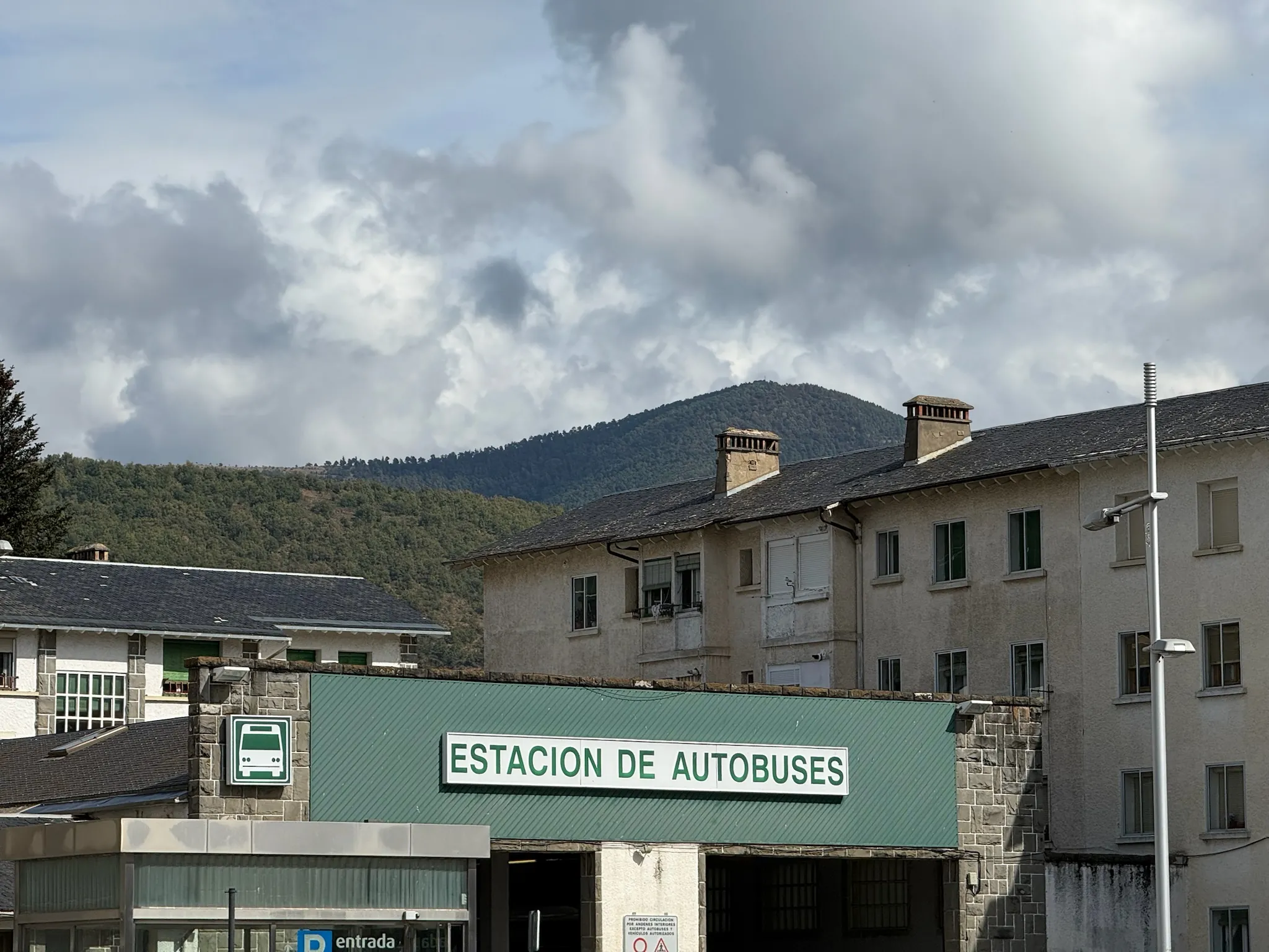 Fachada de la estación de autobuses de Jaca con montañas del Pirineo al fondo y cielo nublado. Foto propia La Maleta Inquieta, octubre 2026