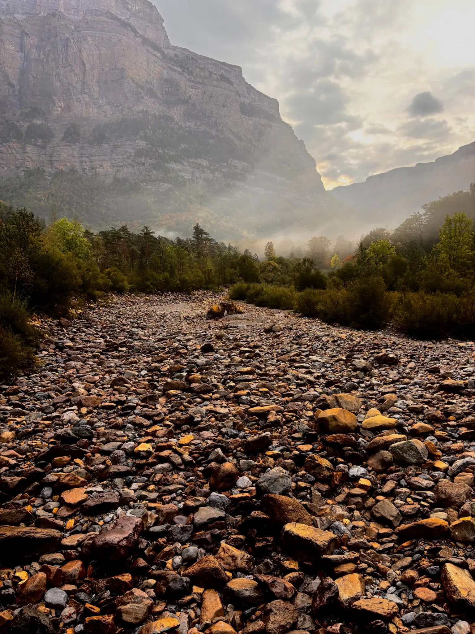 Lecho pedregoso del río con niebla baja entre las paredes de roca del valle de Ordesa. Foto propia La Maleta Inquieta, octubre 2026