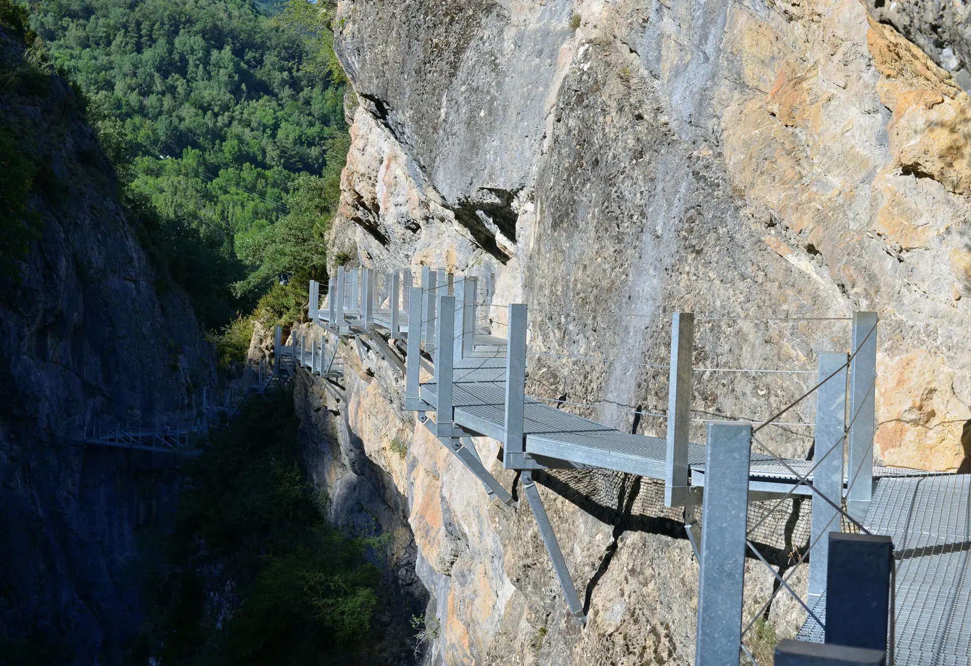 Pasarelas metálicas de Panticosa ancladas a la pared de roca caliza sobre la garganta del río Caldarés, entre bosque