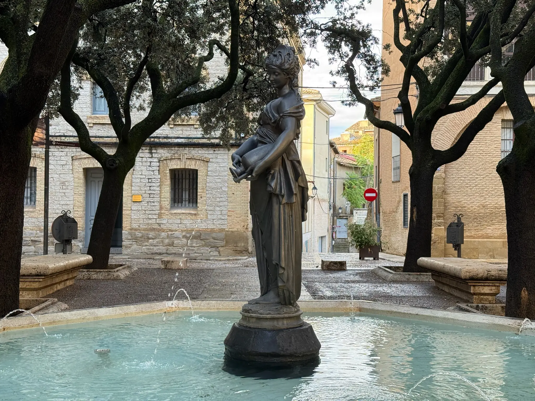 Fuente con estatua femenina en la plaza de la Catedral de Huesca, rodeada de árboles. Foto propia La Maleta Inquieta, octubre 2026