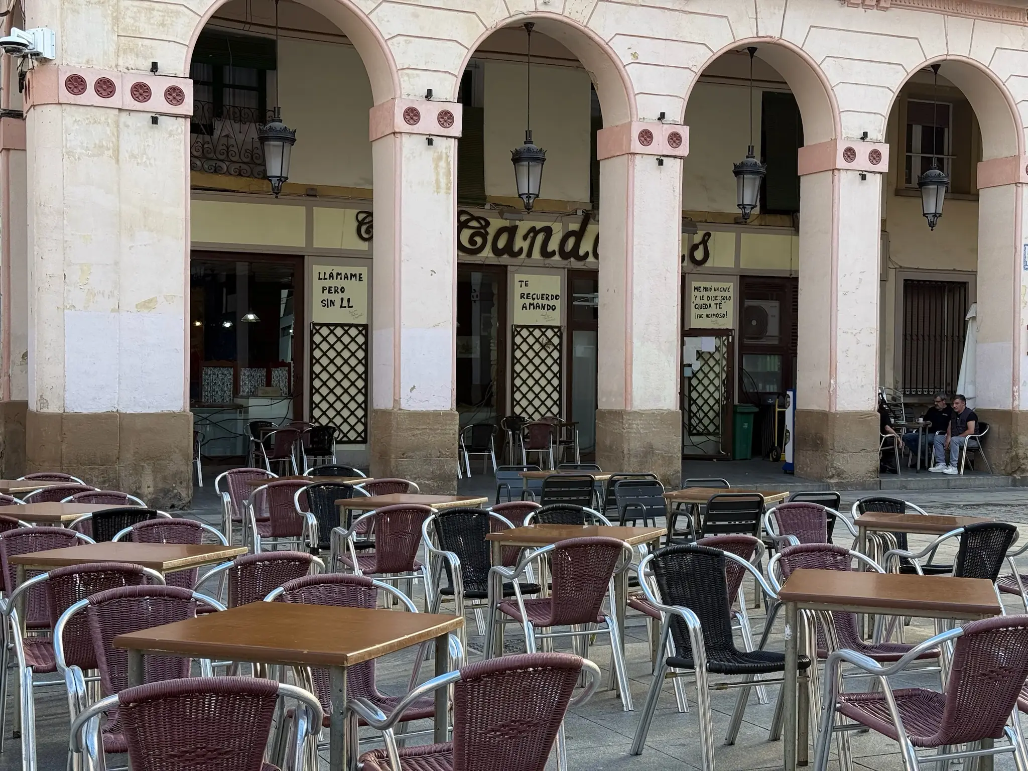Terraza de un bar bajo los soportales de la Plaza López Allué en Huesca, con mesas y sillas de mimbre. Foto propia La Maleta Inquieta, octubre 2026