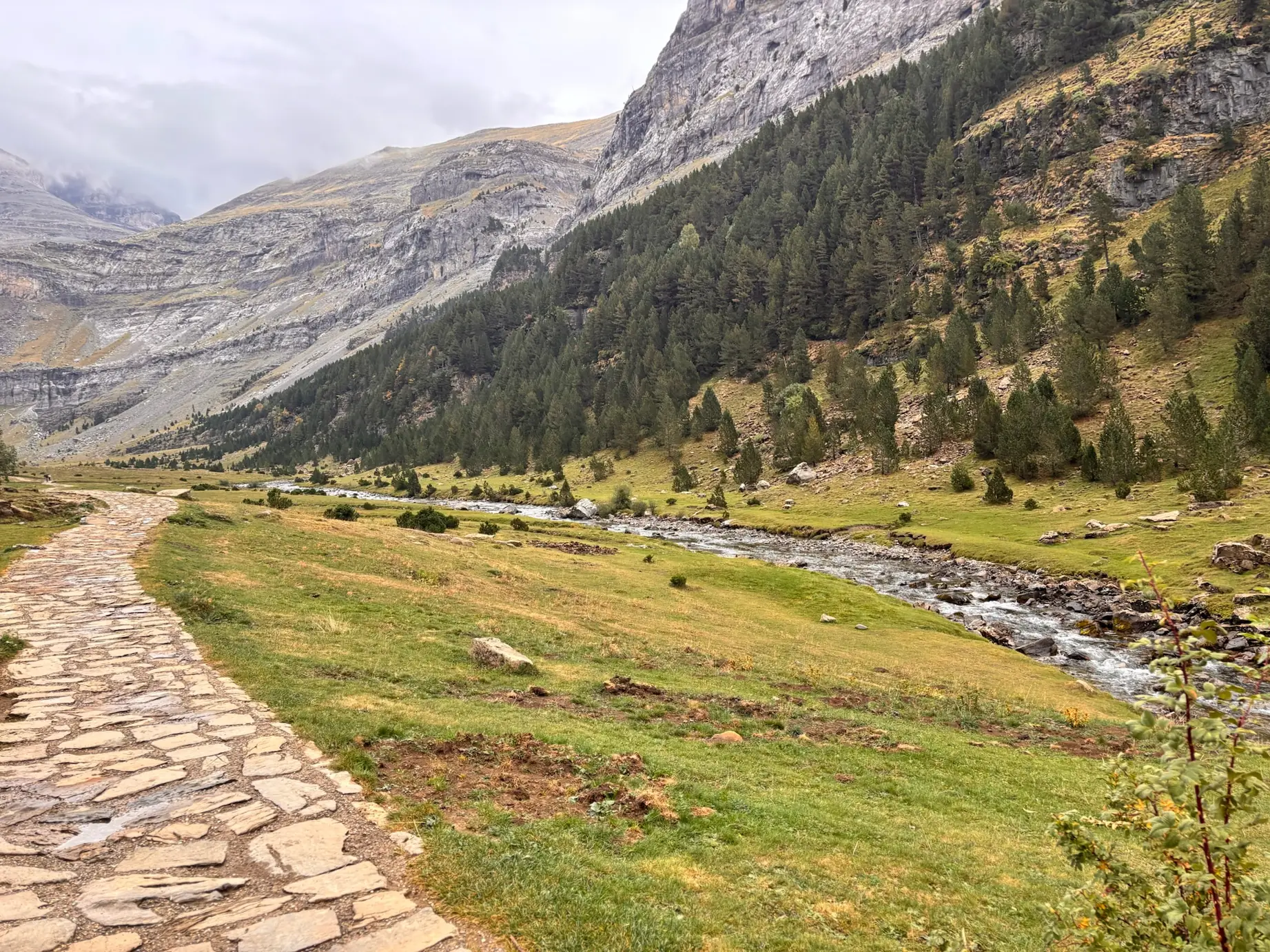 Sendero empedrado junto al río Arazas con las paredes rocosas del valle de Ordesa al fondo. Foto propia La Maleta Inquieta, octubre 2026