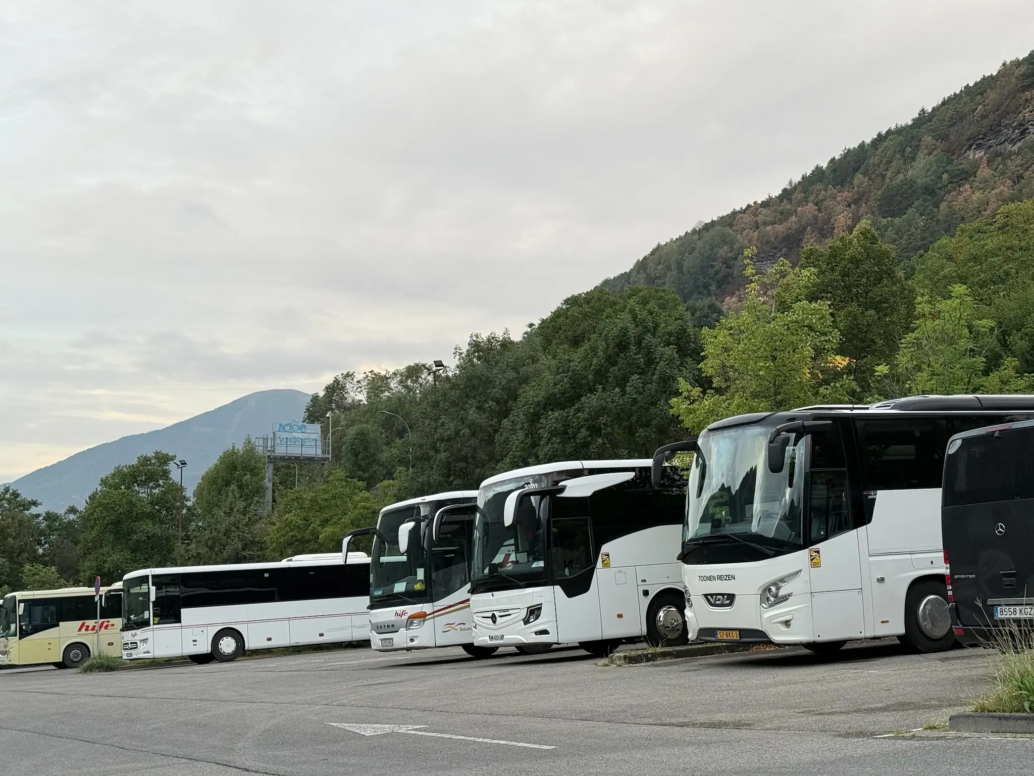 Fila de autobuses blancos del servicio a Ordesa aparcados en Torla con montañas boscosas al fondo. Foto propia La Maleta Inquieta, octubre 2026