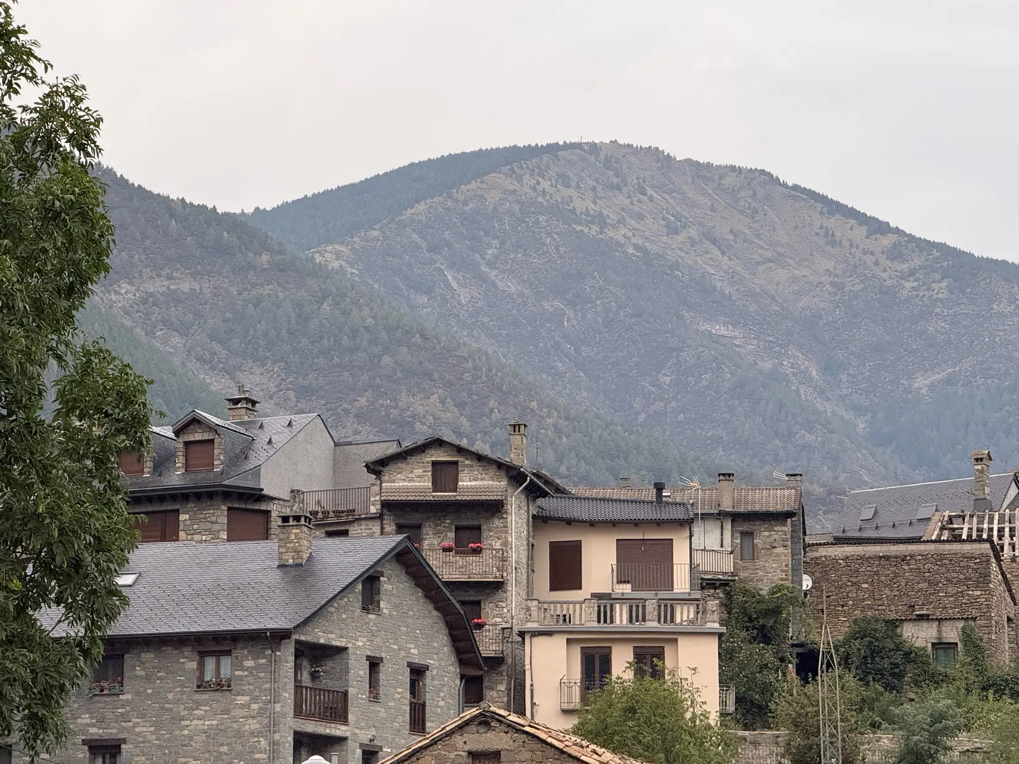 Casas de piedra con tejados de pizarra en Torla con montaña pirenaica cubierta de vegetación al fondo. Foto propia La Maleta Inquieta, octubre 2026