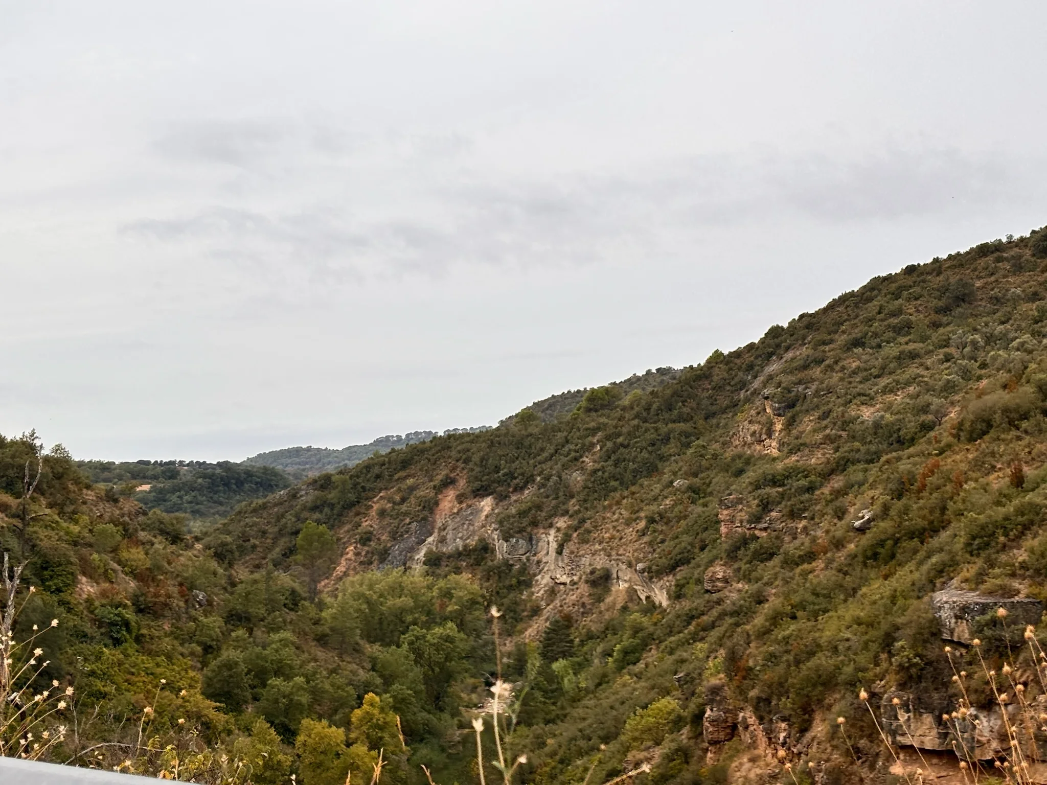 Valle amplio con laderas rocosas calizas y vegetación mediterránea en la Sierra de Guara bajo cielo gris. Foto propia La Maleta Inquieta, octubre 2026