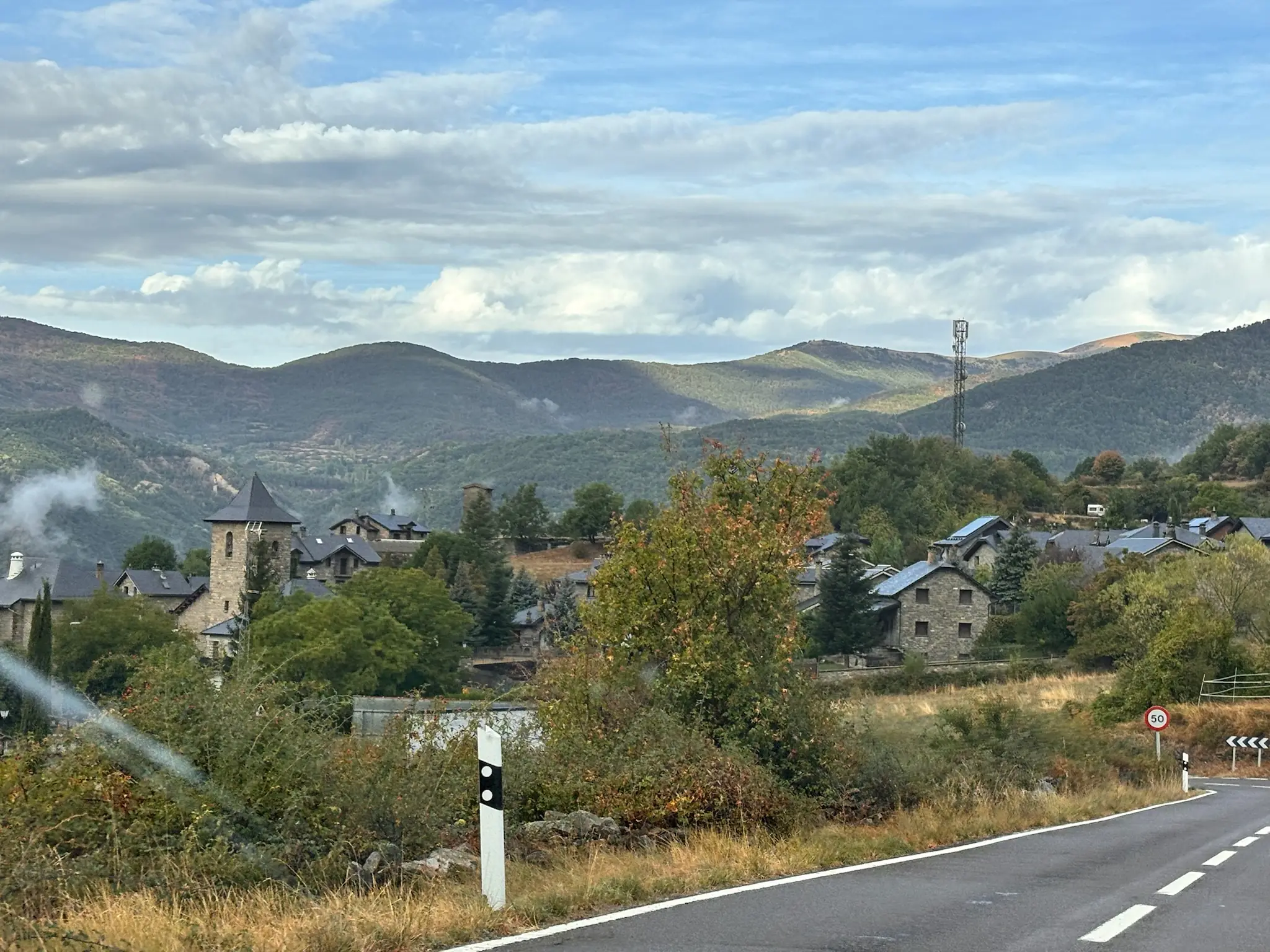 Pueblo del Valle de Tena junto a la carretera, con casas de piedra, torre de iglesia y montañas al fondo. Foto propia La Maleta Inquieta, octubre 2026